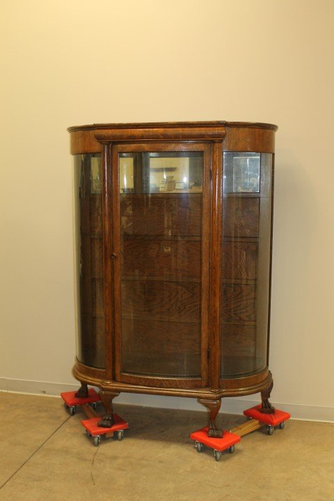 Fine oak curved glass claw foot china cabinet with: Fine oak curved glass claw foot china cabinet with rolled top and interior shelves. Braced back foot. 65 3/4" tall, 49 1/4" wide, 19" deep.