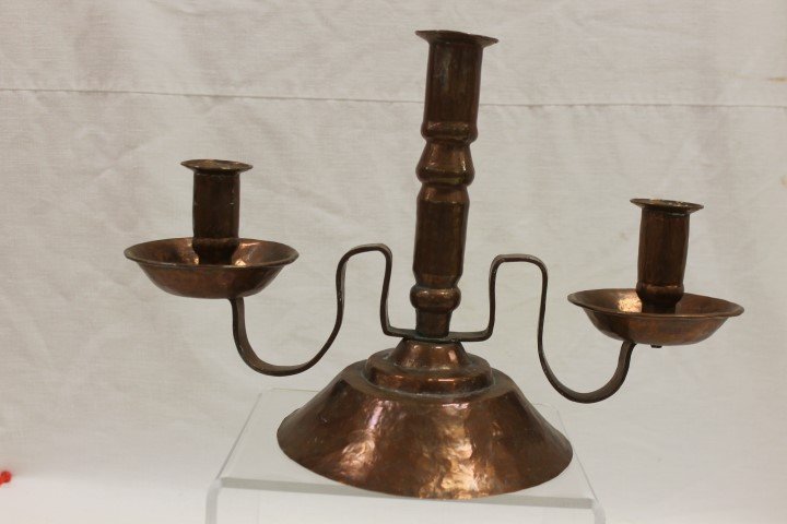 Unmarked hammered copper triple candlestick on a three: Unmarked hammered copper triple candlestick on a three tier base, app. 9 1/8" tall, 13 3/4" wide.