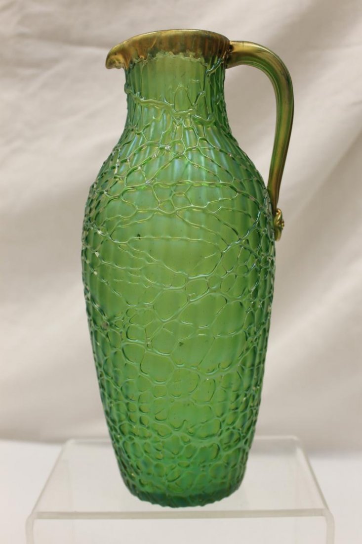 Fine Loetz pitcher with applied gold handle and fishnet: Fine Loetz pitcher with applied gold handle and fishnet body with gold rim. Green/blue irridescent piece, with gold rim, 10 3/8", minor gold wear.