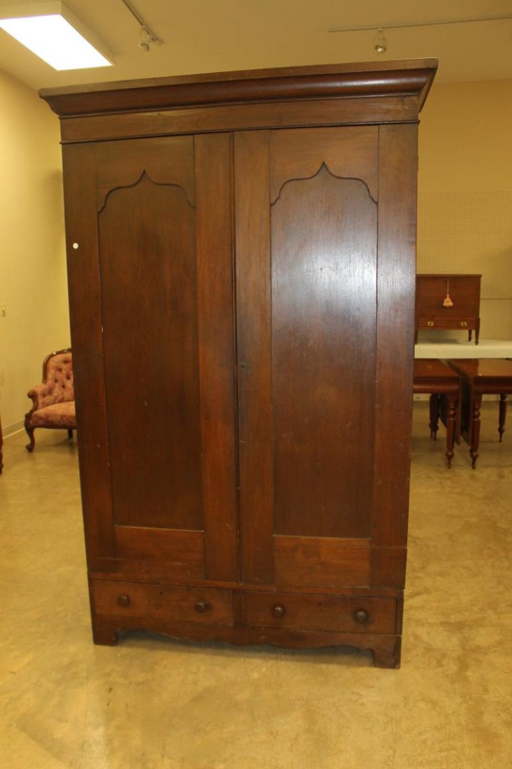 Walnut wardrobe with two doors over t drawers. Solid: Walnut wardrobe with two doors over t drawers. Solid board sides, scalloped apron, molded cornice. Some loss, with Gothic door panels. 83 1/2" tall, 52 1/2" wide, 22 3/8" deep
