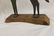 Mounted sheet iron horse on wooden base, with strap at - 5
