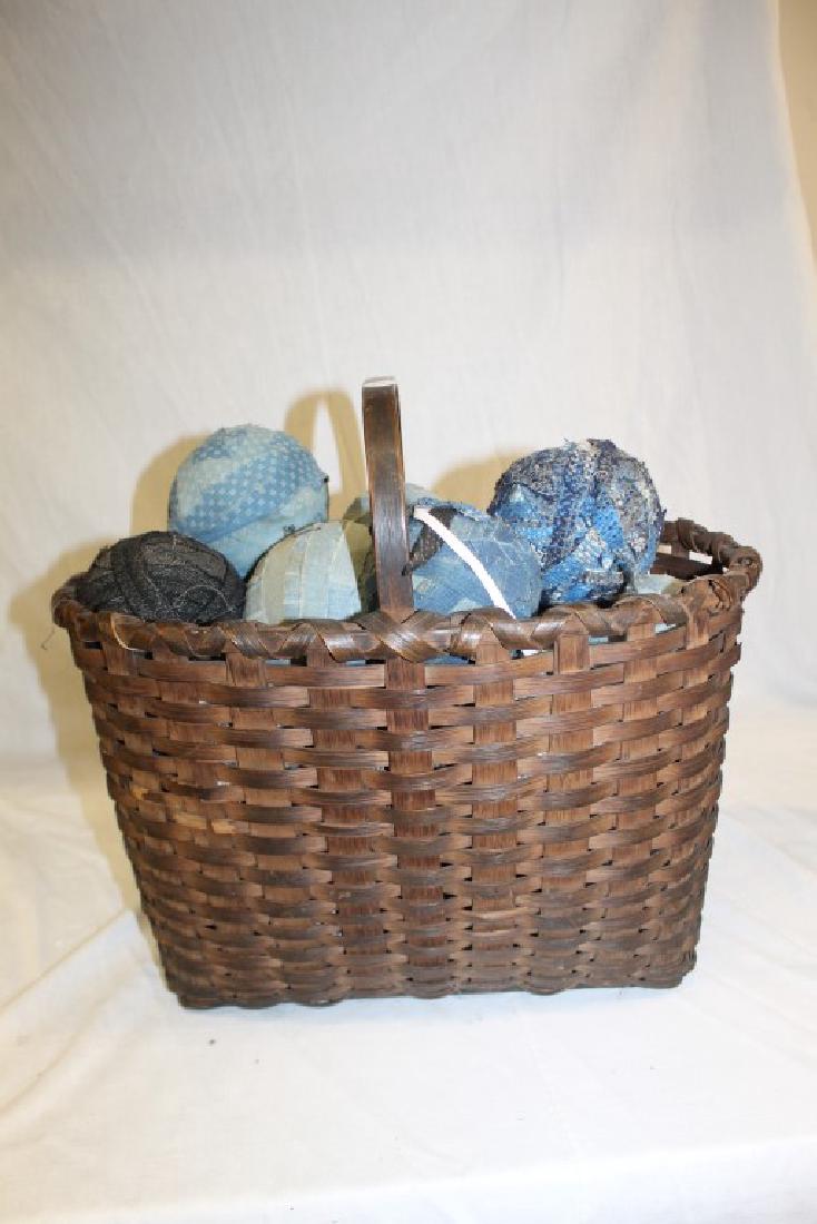 Tall woven basket with balls of material and bentwood: Tall woven basket with balls of material and bentwood handle fitted to lock to the basket rim support. 16" tall, 17" deep