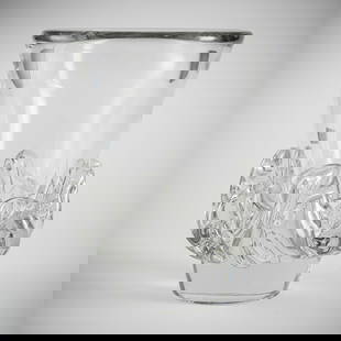A LARGE CRYSTAL GLASS VASE: A LARGE CRYSTAL GLASS VASEDaum, Nancy, 1960iesH. 28,5 cmDesign by Jean Daum. Colourless glass, with relief melting at the base of the rim. At the lower rim etched signature "Daum Nancy France" with