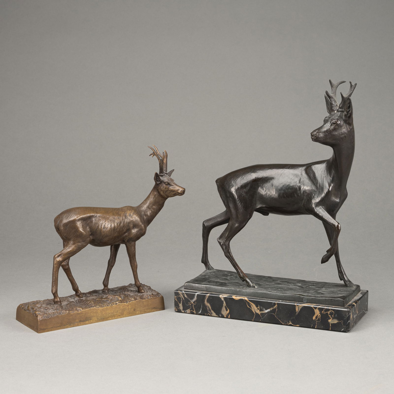 TWO ROEBUCKS: TWO ROEBUCKS20th centuryH. 19,5 cm, H. 25/28 cmBronze, one patinated. The smaller roe buck without signature. The larger one by Fritz Diller, signed, veined black marble plinth. Slightly worn.The Finc