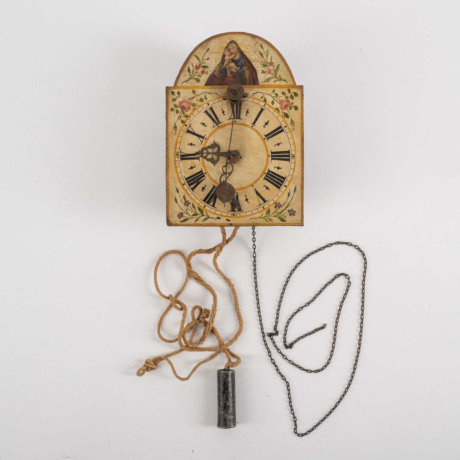A SOUTH GERMAN IRON WALL CLOCK: A SOUTH GERMAN IRON WALL CLOCK2nd half 18th centuryH. 28 cmPainted iron front with Madonna, Roman numerals, decorated brass hands, and short front pendulum. Closed iron movement with side doors, 1-day