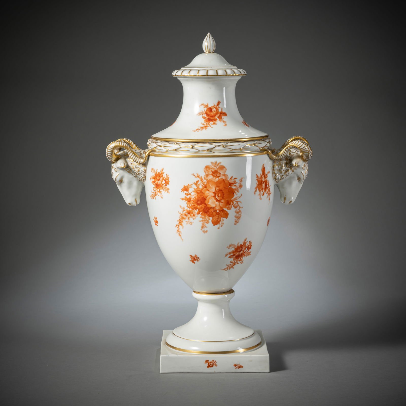 A LARGE FURSTENBERG AMPHORA VASE AND LID: A LARGE FURSTENBERG AMPHORA VASE AND LIDFürstenberg, 20th centuryH. 56 cmWith ram head handles, gilding and iron red painted bouquet of flowers, blue F-mark to bottom and gold ciffers. Minor wear