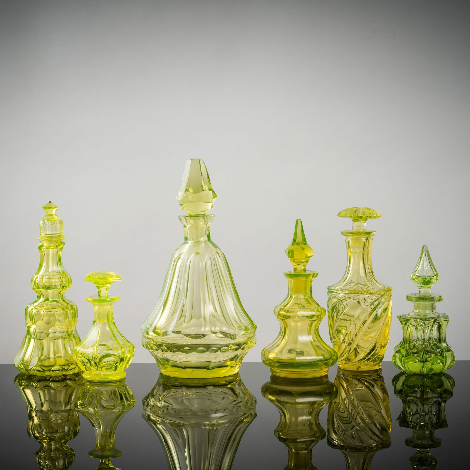 SIX GLASS FLASKS: SIX GLASS FLASKSBohemia, 19th centuryH. 11/ 23 cmAnnagreen glass and others, of various shapes, slightly chippedSouth German private collectionSechs Glas-FlakonsBöhmen, 19. Jhdt.H. 11/ 23 cmAnnag