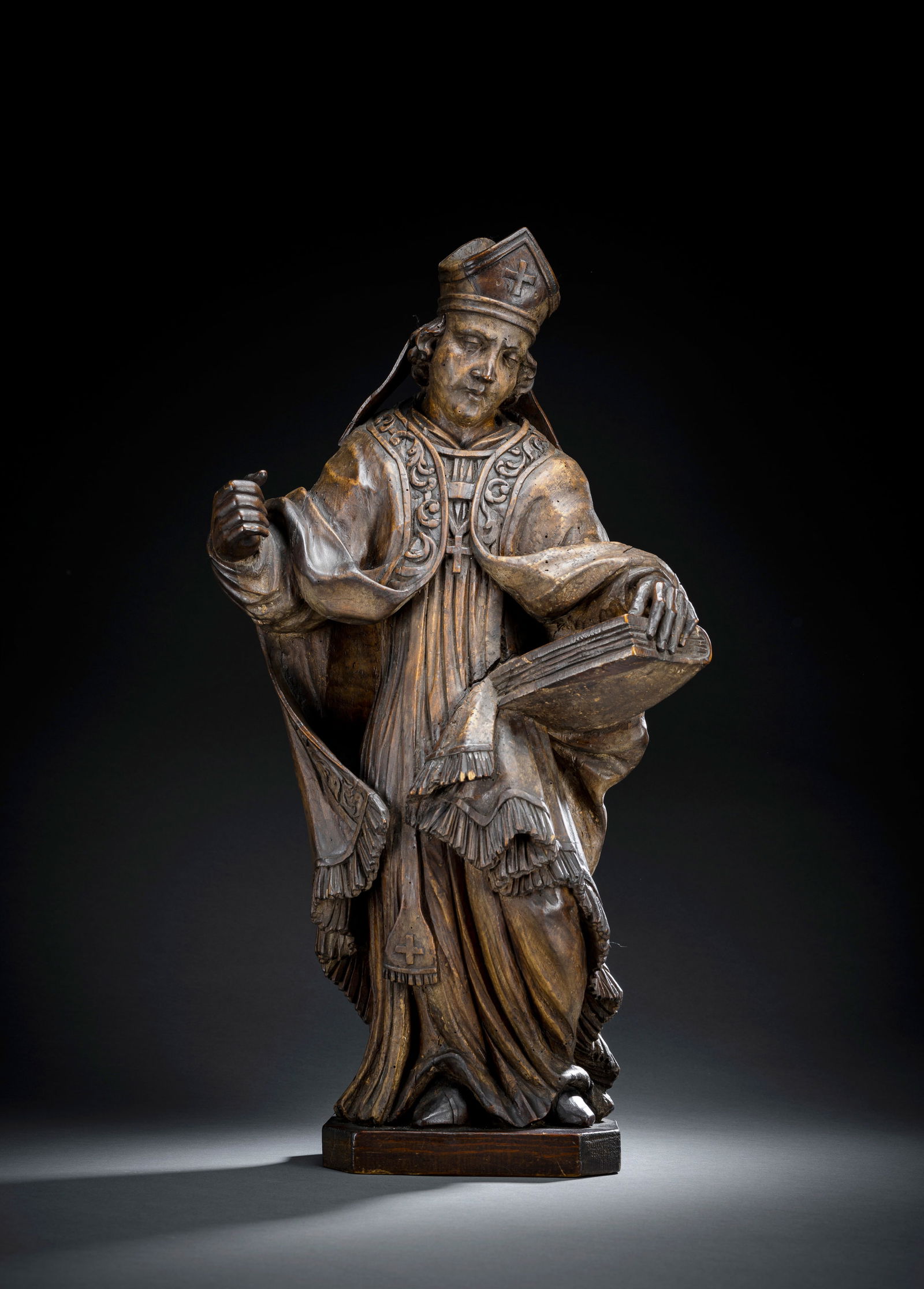 A BAROQUE FIGURE OFA HOLY BISHOP: A BAROQUE FIGURE OFA HOLY BISHOP possibly Lower Franconia, ca. 1700 H. 63 cm Hardwood, probably linden, carved with flattened back. Later stained and coated with varnish. Newly added base. Right