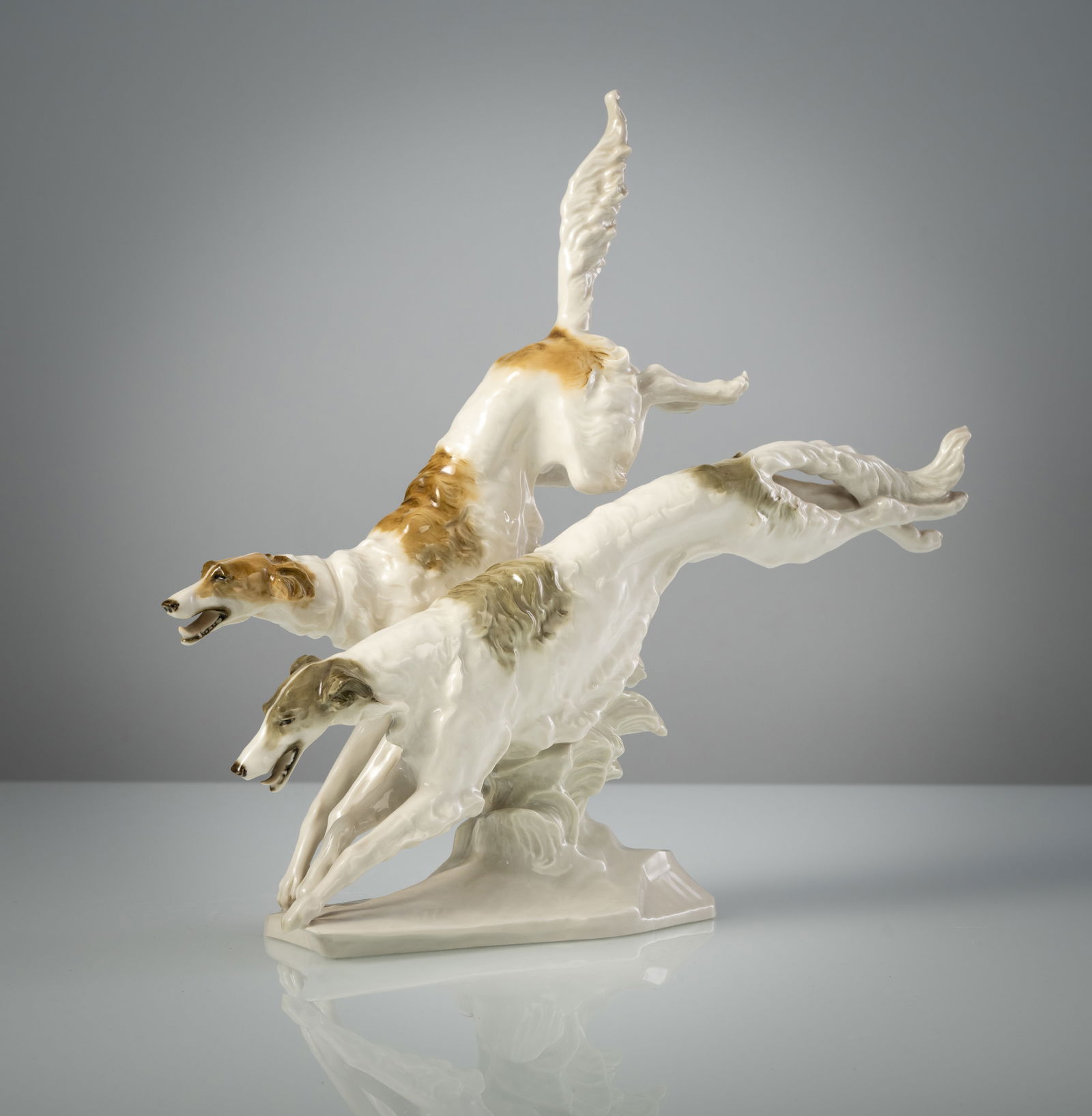 A PAIR OF BORZOI DOGS: A PAIR OF BORZOI DOGS Karl Tutter for Hutschenreuther L. 34 cm Signed K.TUTTER and blue company's mark by Hutschenreuther Selb Kunstabteilung, minute chip to one claw.Porzellangruppe von zwei Barsoi
