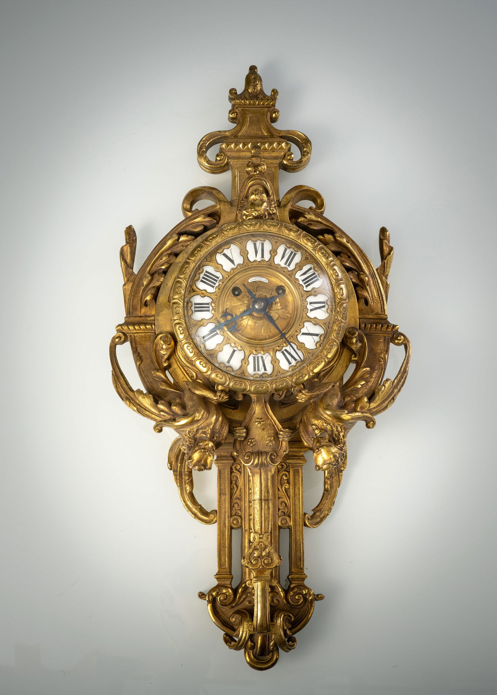 A GERMAN WALL CLOCK: A GERMAN WALL CLOCK 2nd half 19th century H. 55 cm Bronze case with griffins, enamelled dial and enamel plaque signed "JOH. HARTMANN BERLIN". Movement not working, damages due to age.Cartel-Uhr 2.