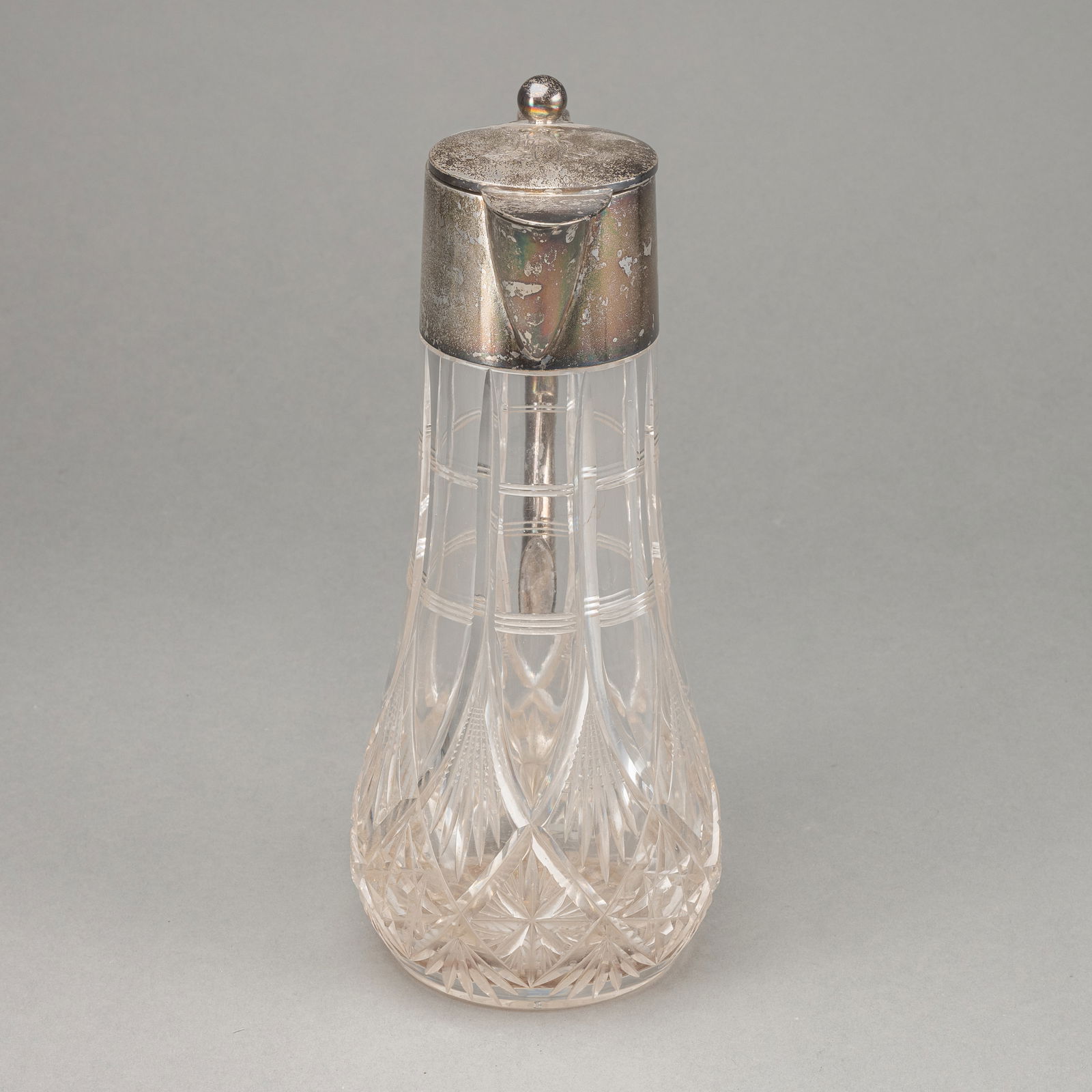 A SILVER MOUNTED WINE JAR: A SILVER MOUNTED WINE JAR Wilkens and Söhne, Bremen, circa 1920/30 H. 28,5 cm Cut glass, lid with monogram engraving. Company mark, seller's mark FOEHR (Stuttgart), fineness 800, model no.