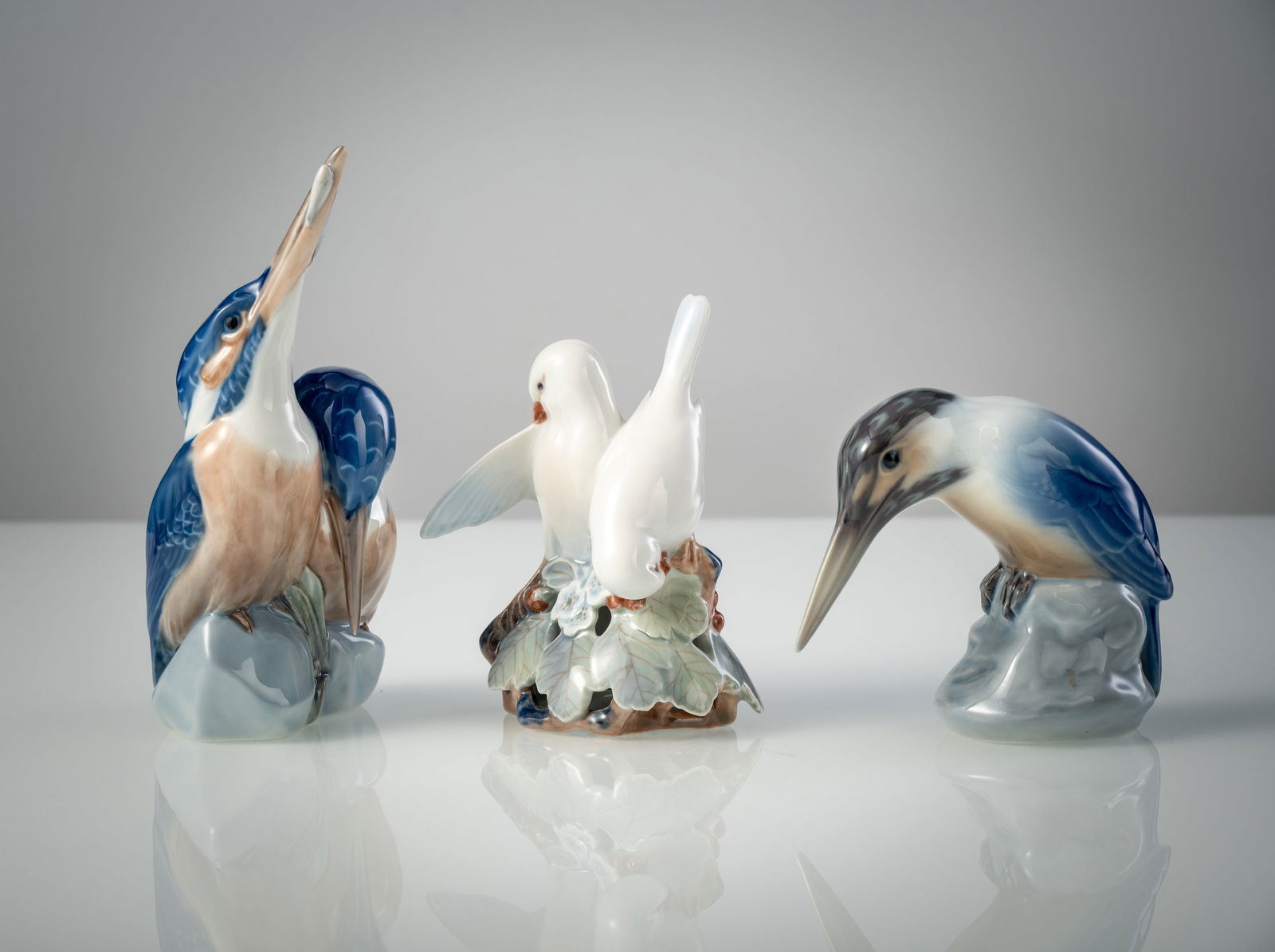 THEE ROYAL COPENHAGEN BIRD FIGURES: THEE ROYAL COPENHAGEN BIRD FIGURES 1937 H. 11-18,3 cm Pair of kingfishers, pair of white doves and kingfisher. Blue wave marks, green stamp marks, scratch marks.Drei Vogelfiguren Royal Copenhagen,