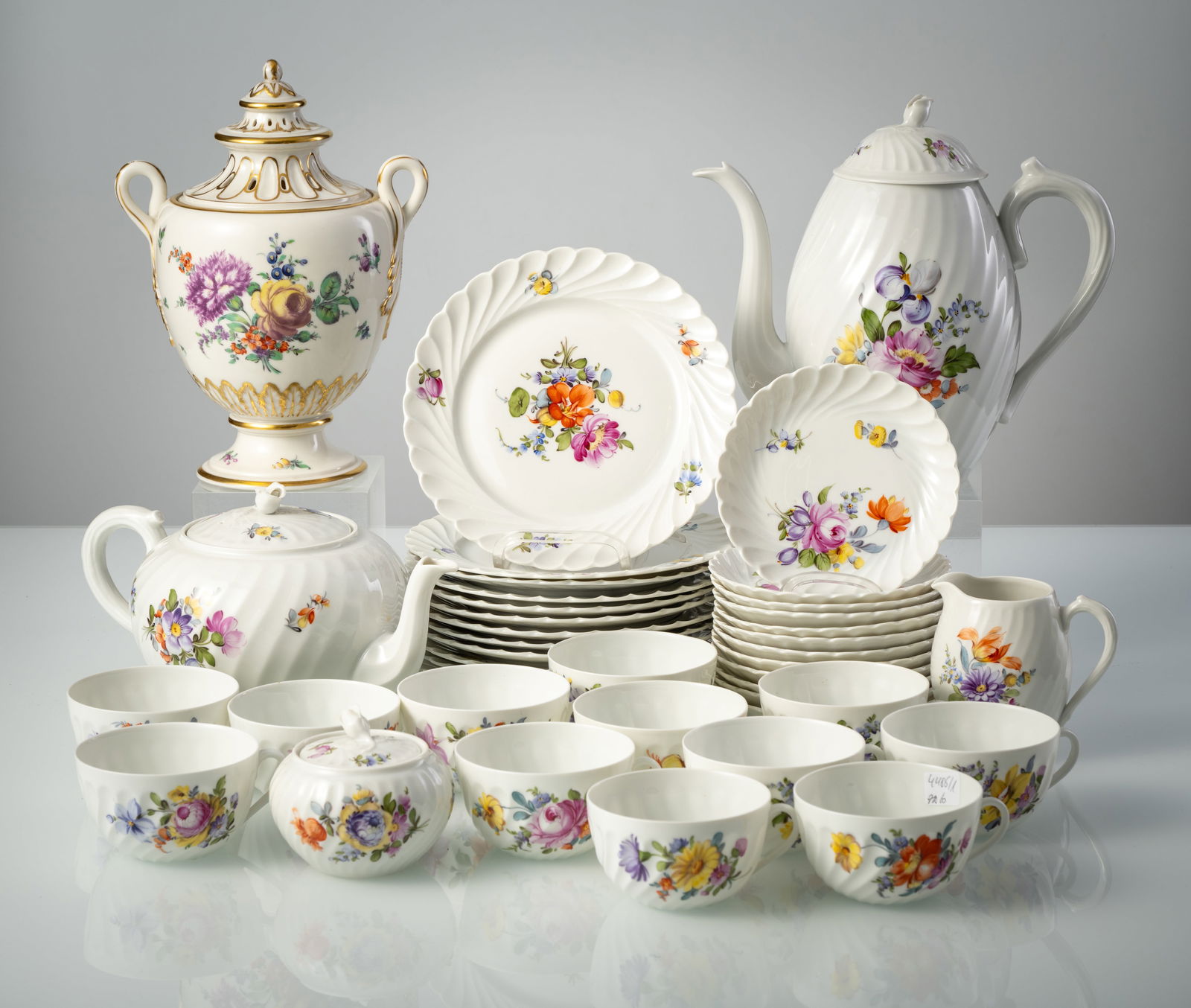A NYMPHENBURG COFFEE AND TEA SERVICE "WELLE" AND A VASE WITH COVER: A NYMPHENBURG COFFEE AND TEA SERVICE "WELLE" AND A VASE WITH COVER 20th century divers Polychrome floral painting, pressed diamond-shaped shield, green stamp mark, painter's marks. 12 cups, 12