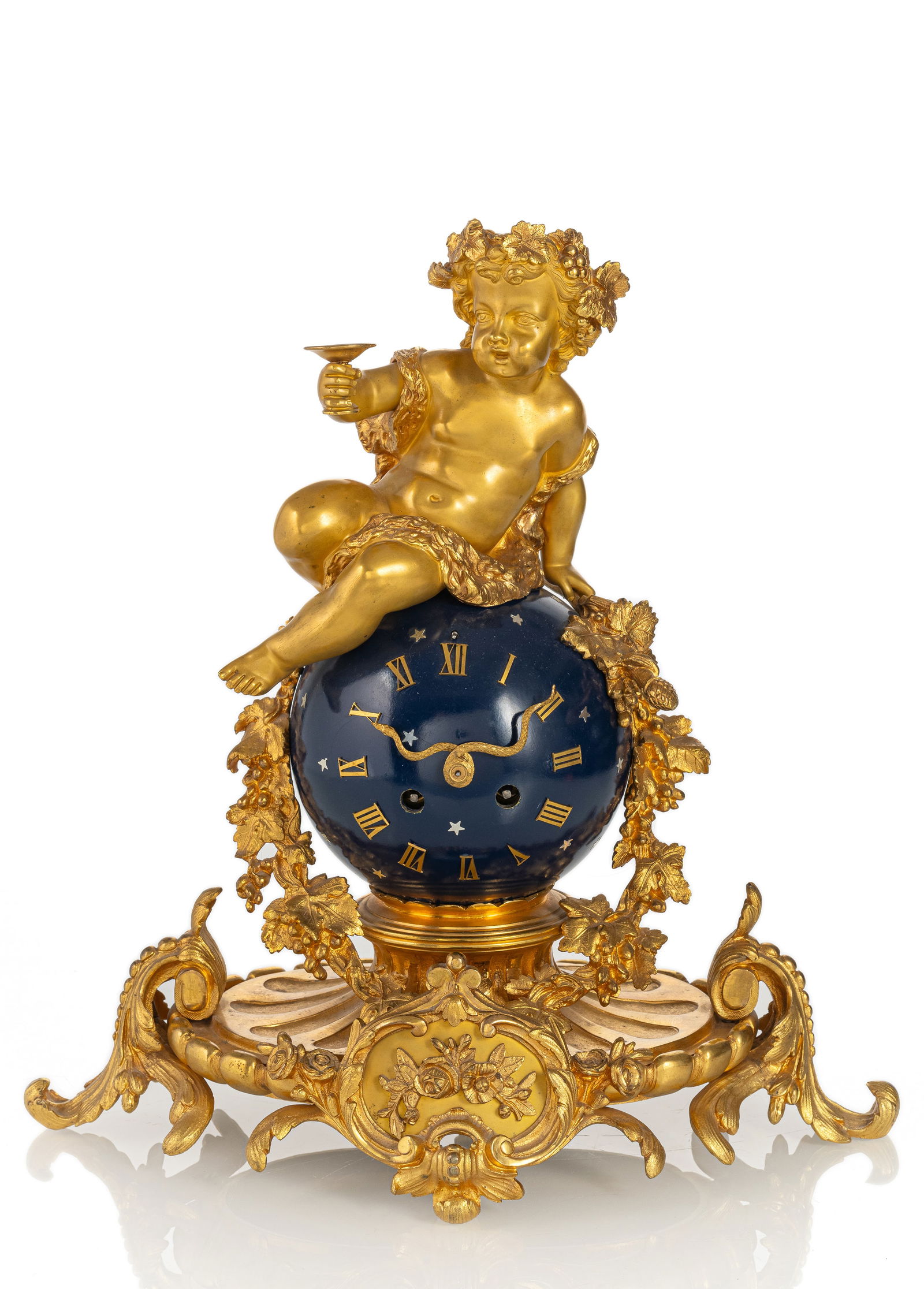 A GILTBRONZE LOUIS XV STYLE PENDULE: A GILTBRONZE LOUIS XV STYLE PENDULE Paris, 19th century 36 x 32 cm Richly decorated, gilt bronze case with Bacchus on a stylised, blue lacquered globe. Applied Roman numerals, snake shaped hands.