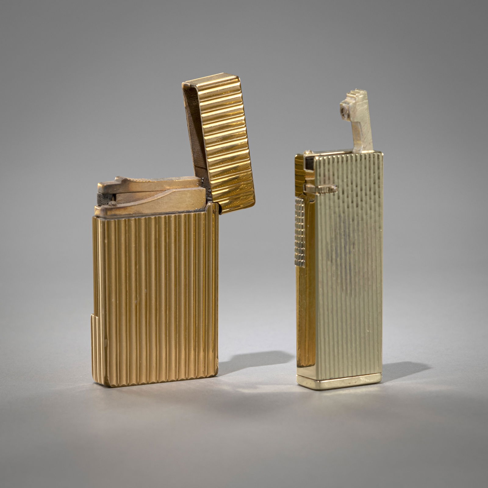 TWO LIGHTERS: TWO LIGHTERS DUPONT/LINEAR L. 6/6,5 cm Gilded. Dupnt lighter with no. 8JCR35Zwei Feuerzeuge Dupont, Linear L. 6/6,5 cm Vergoldet, Dupont Feuerzeug mit Nr. 8JCR35