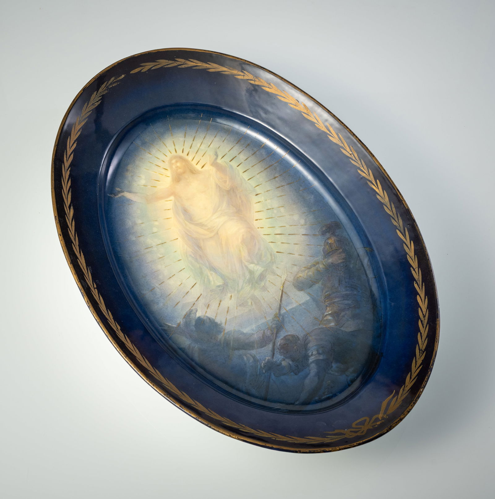 A LARGE OVAL PORCELAIN DISH WITH RESURRECTION SCENE: A LARGE OVAL PORCELAIN DISH WITH RESURRECTION SCENE Vienna (?), maybe Franz Dörfl, late 19th/early 20th century 56 x 37,5 cm Printed and gilt. ‘Bindenschild’ mark in blue on the