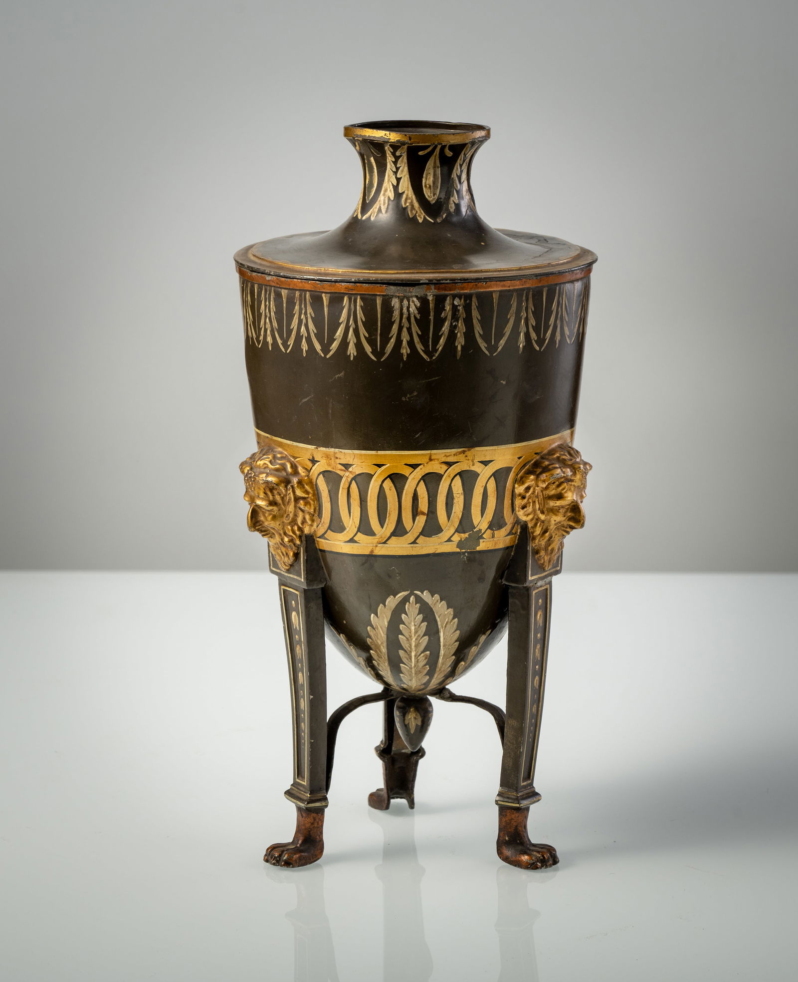 A PAINTED METAL URN SHAPED VASE AND COVER: A PAINTED METAL URN SHAPED VASE AND COVER probably England, early 19th century H. 35 cm The lid with upper hole. Painted in green, silver and gold. Restorations and some damages.Empire-Vase in