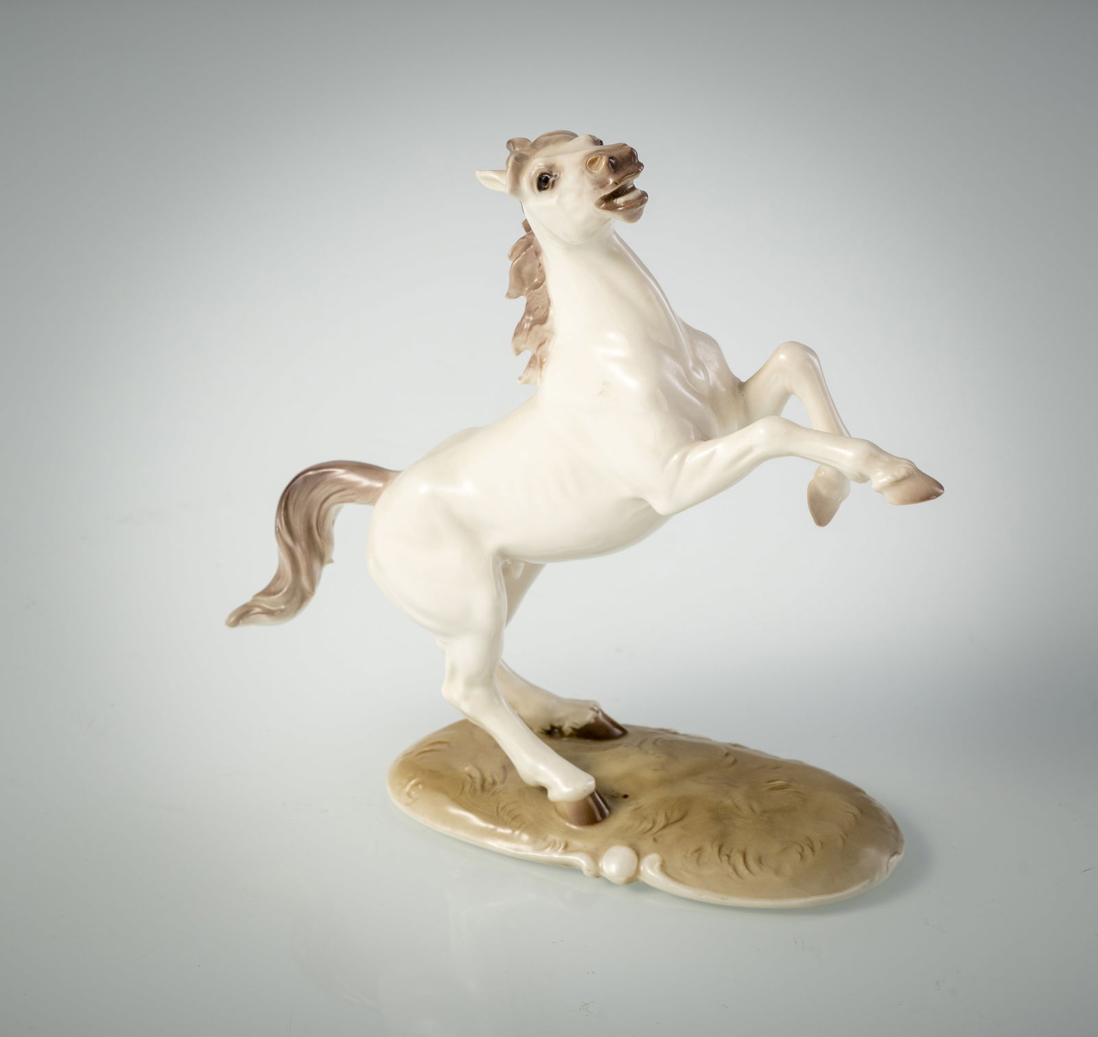 A NYMPHENBURG FIGURE OF A RISING HORSE: A NYMPHENBURG FIGURE OF A RISING HORSE 20th century H. 17 cm The model by August Göhring, impressed lonzegne shield, no. 800/5, green stamp mark and WESTERN GERMANY. Minor wearSteigendes Pferd