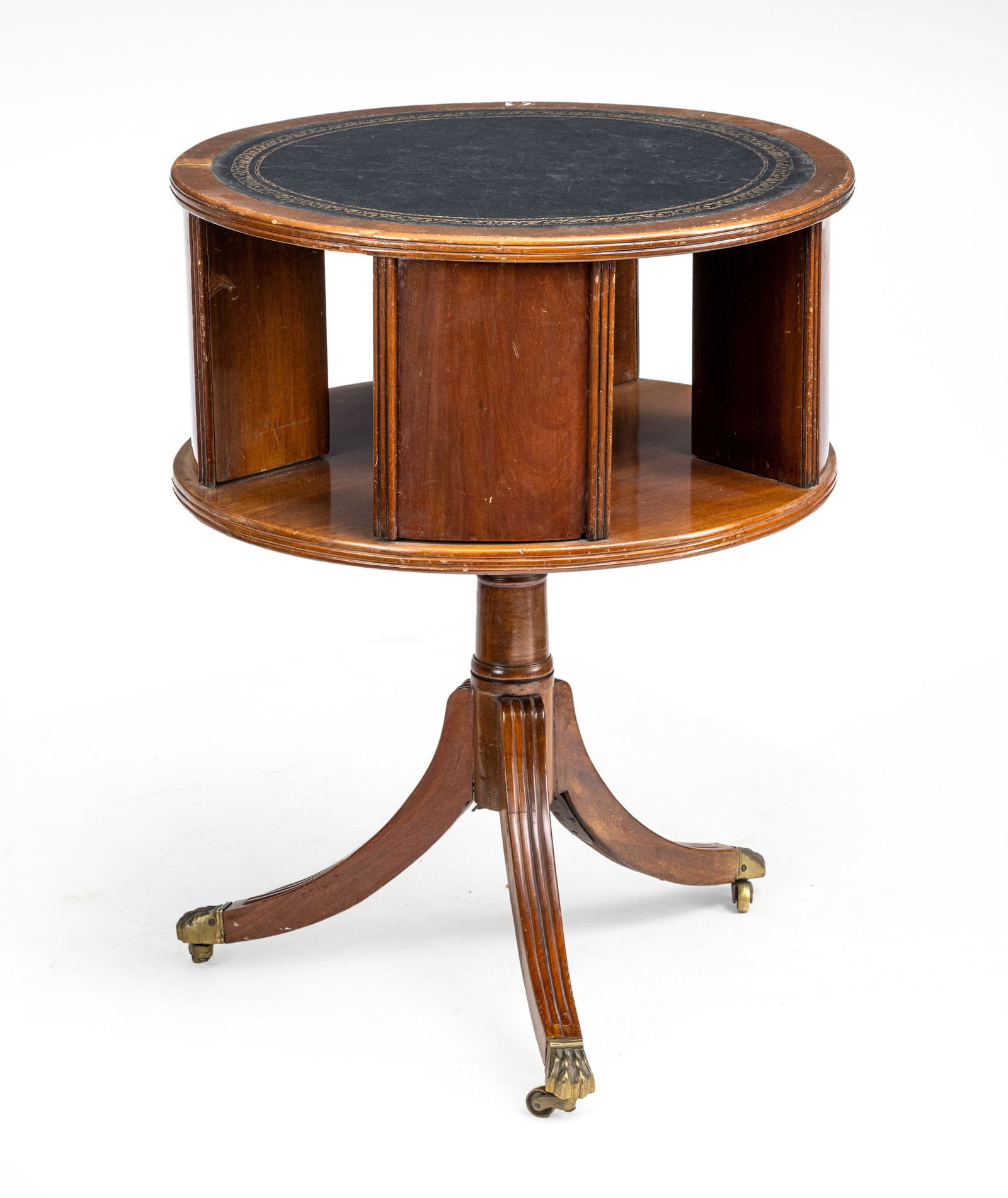 A BRASS MOUNTED AND LEAHTER LINED MAHOGANY CYLINDRICAL BOOK STAND: A BRASS MOUNTED AND LEAHTER LINED MAHOGANY CYLINDRICAL BOOK STAND England H. 71/D. 53 cm The top with leather liner, the tripot stand ending in paw feet and brass casters. Damages due to use and
