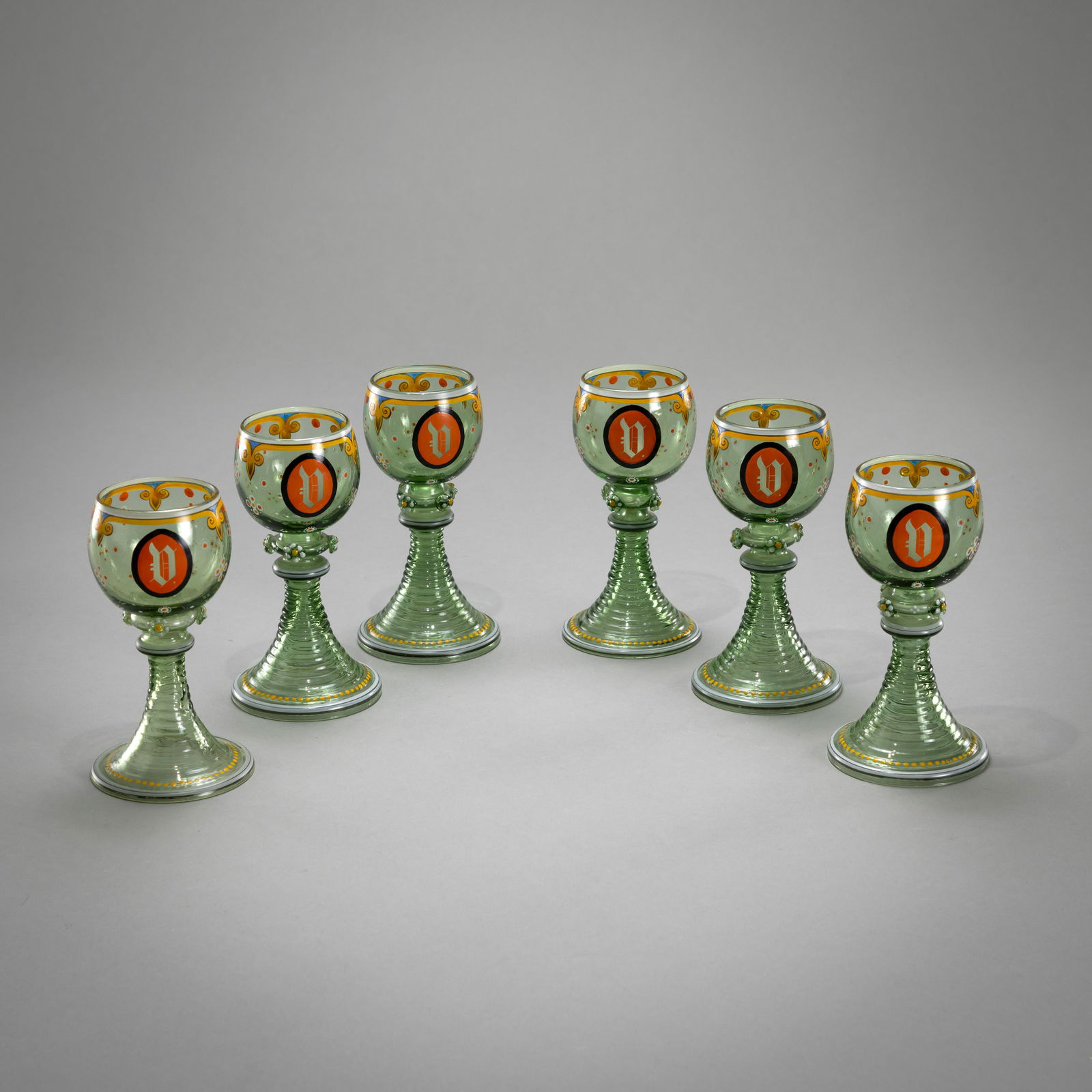 SIX RUMMER GLASSES: SIX RUMMER GLASSES probably Egermann, 19th century H. 14,5 cm Green, enamel painted glass.Sechs Historismus Römer Wohl Egermann, 19.Jh. H. 14,5 cm Grünes Glas mit Emailbemalung und in