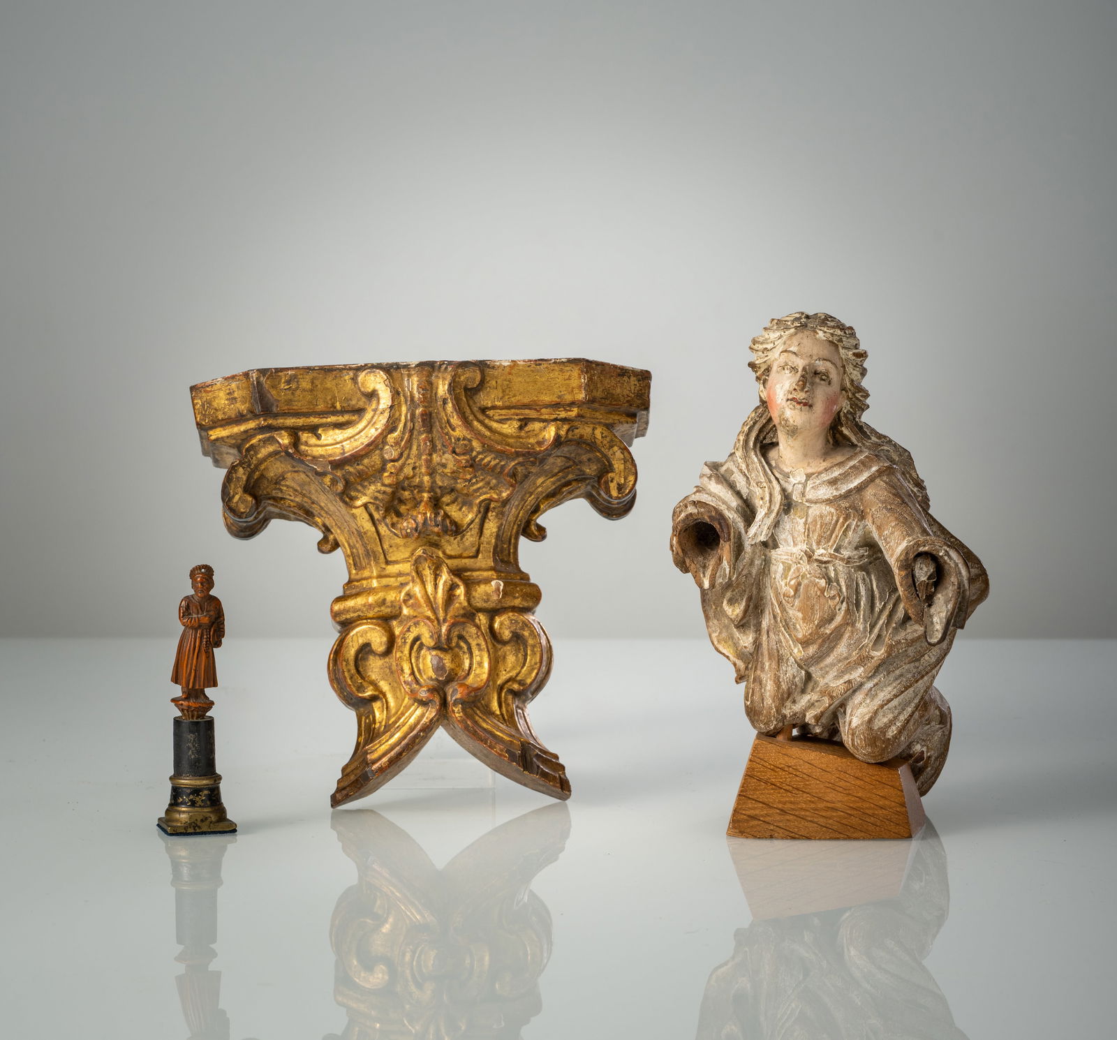 A CARVED AND GILT WOOD MINIATURE CONSOLE; A CARVED ANGEL FRAGMENT WITH STAND AND A SEAL: A CARVED AND GILT WOOD MINIATURE CONSOLE; A CARVED ANGEL FRAGMENT WITH STAND AND A SEAL 18th/19th century H. 10/15/19 cm The seal with a miniature figure of a Saint of carved boxwood or nut. Minute