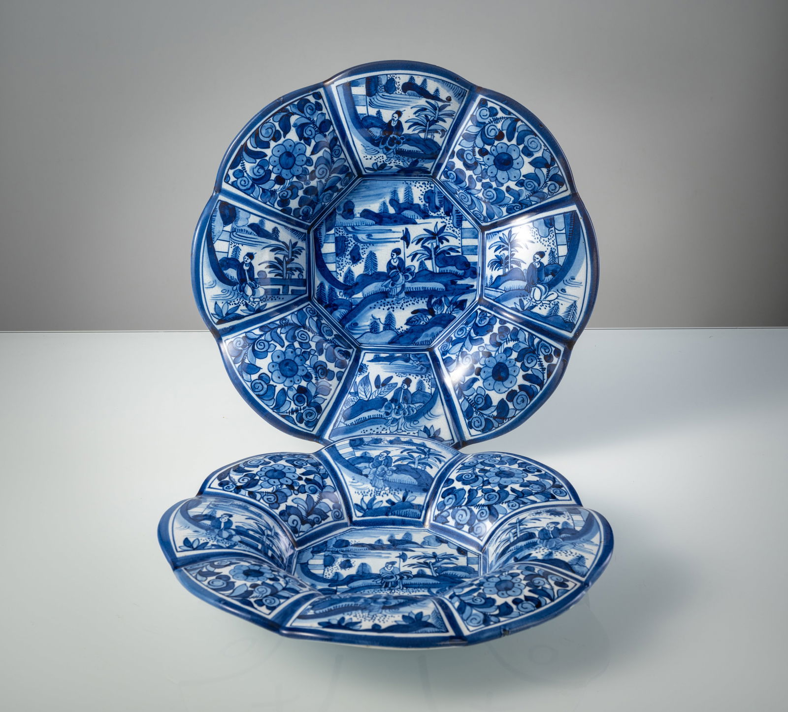 TWO BLUE PAINTED CHINOISERIE PATTERN FAIENCE DISHES: TWO BLUE PAINTED CHINOISERIE PATTERN FAIENCE DISHES Delft, probably around 1900 D. 34 cm With company mark at the bottom. Minute wear.Zwei Buckelplatten mit Chinoiseriedekor Delft, wohl um 1900 D. 34
