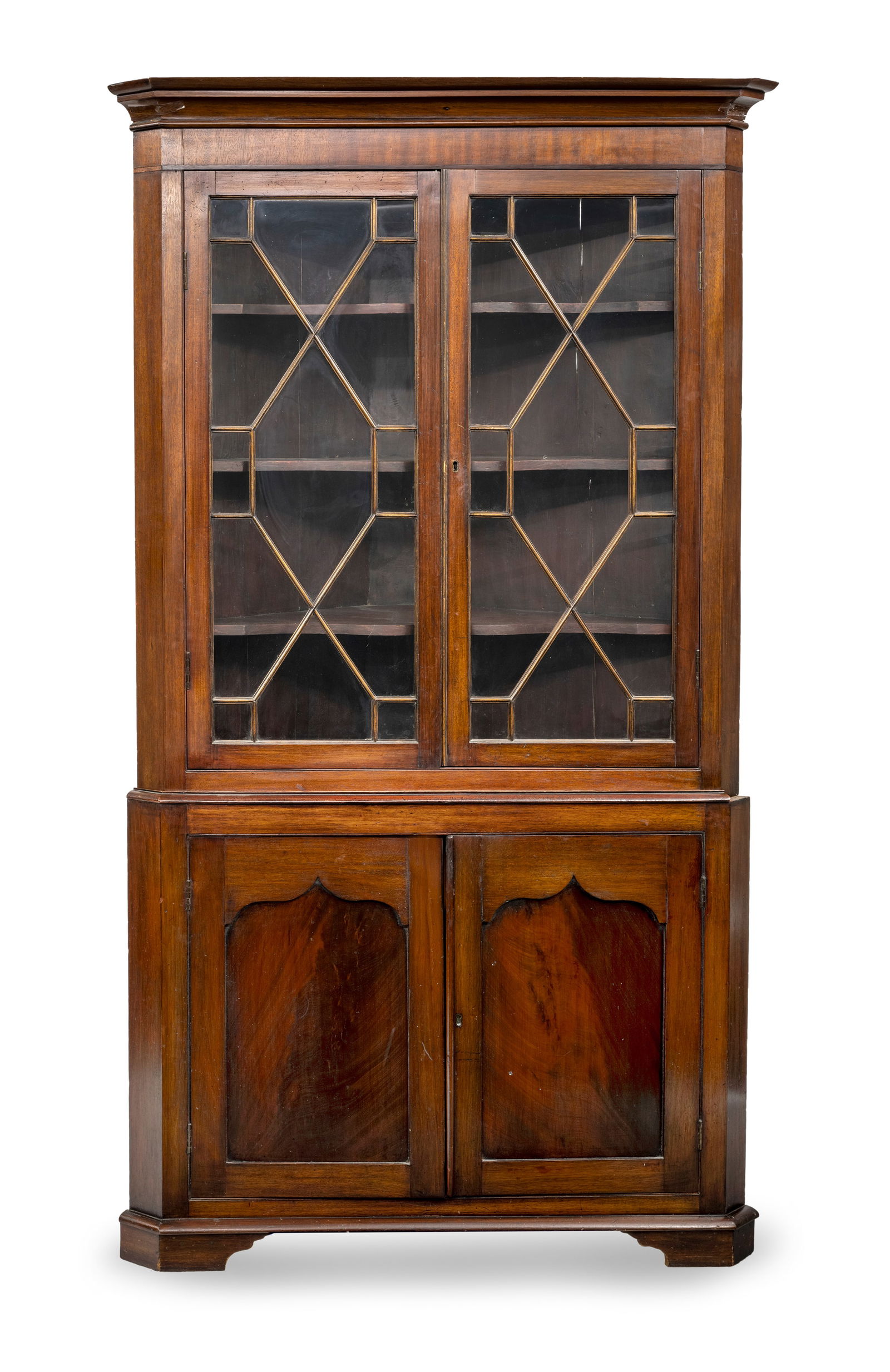 A BRASS MOUNTED MAHOGANY CORNER DISPLAY CUPBOARD: A BRASS MOUNTED MAHOGANY CORNER DISPLAY CUPBOARD England, late 19th century H. 208/Sl 83 cm The upper part with two decorated openworked display doors. Damages due to age, losses,