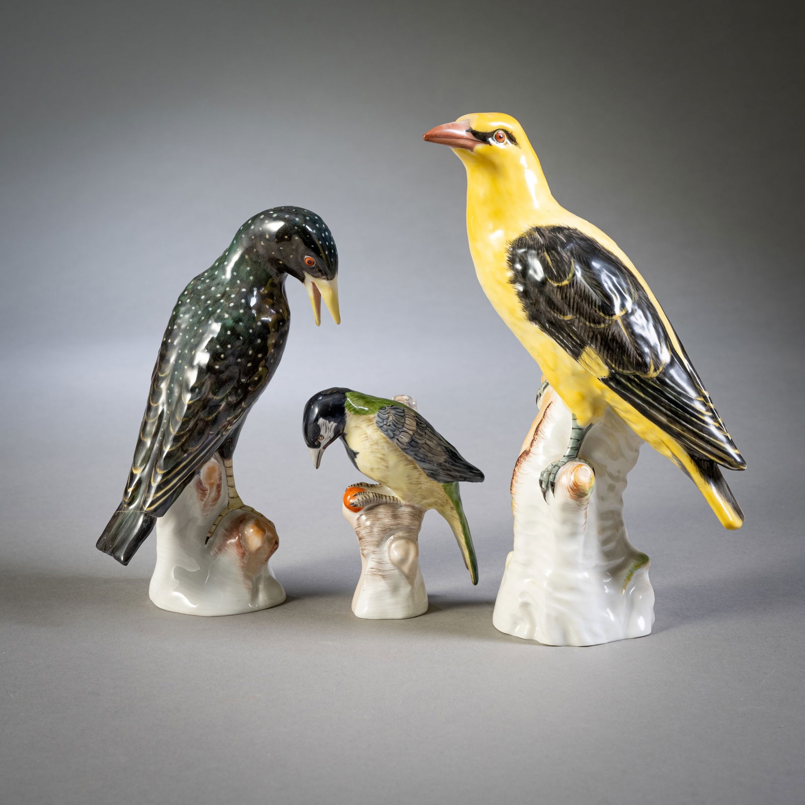 THREE BIRDS, KPM: THREE BIRDS, KPM Berlin, 20th century. H. 10,5/22,5 cm Three birds (starling, oriole and titmouse), KPM, 1st choice, with blue sceptre mark and red orb mark. Tail of the starling rep.Drei Vögel