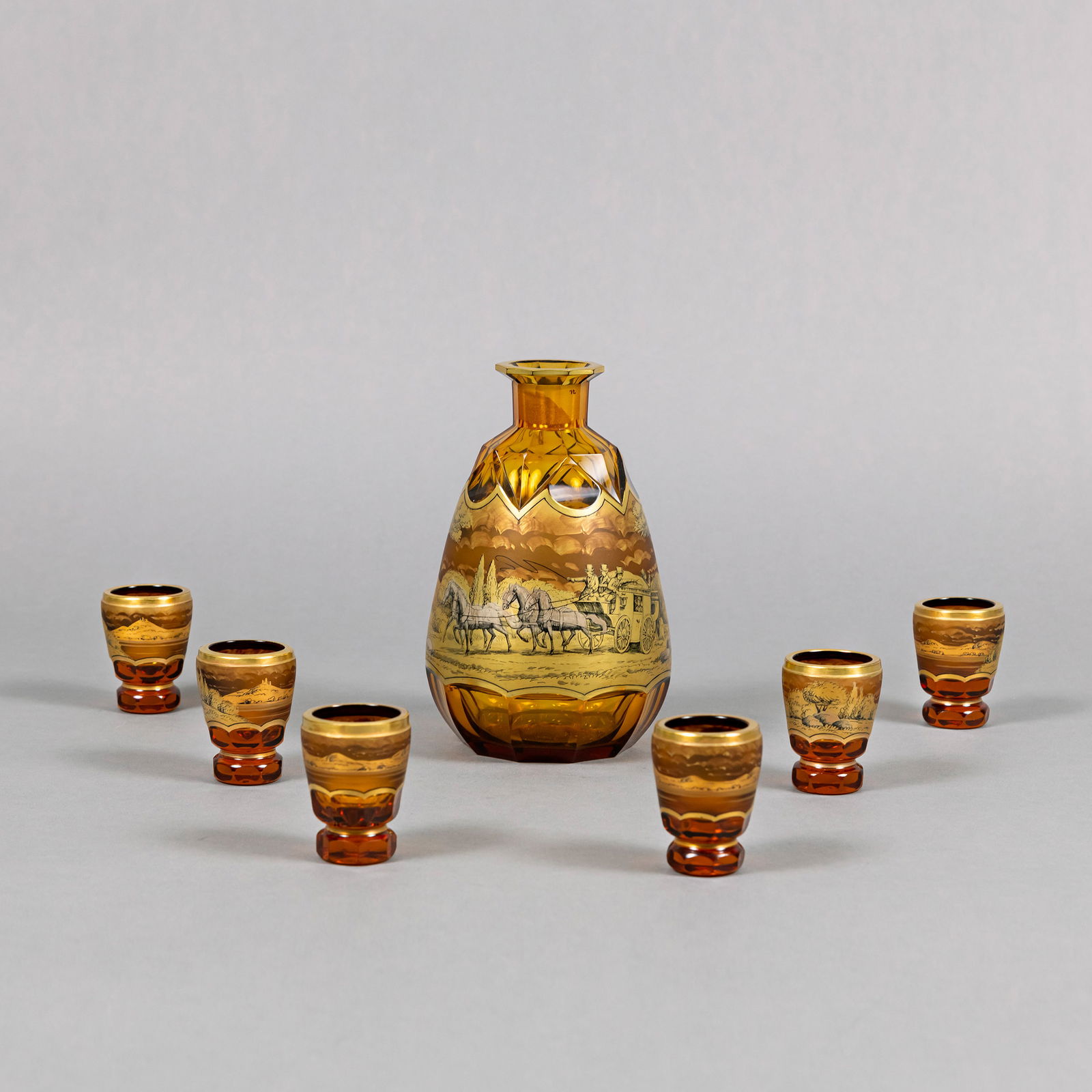 A CARAFE AND 6 SCHAPPS GLASSES: A CARAFE AND 6 SCHAPPS GLASSES MOSER/KARLSBAD H. 6/18,5 cm Brownish glass, painted in silver, grisaille and gold with carriage and landscapes.Karaffe und 6 Schnapsgläser Moser/Karlsbad H. 6/18,5