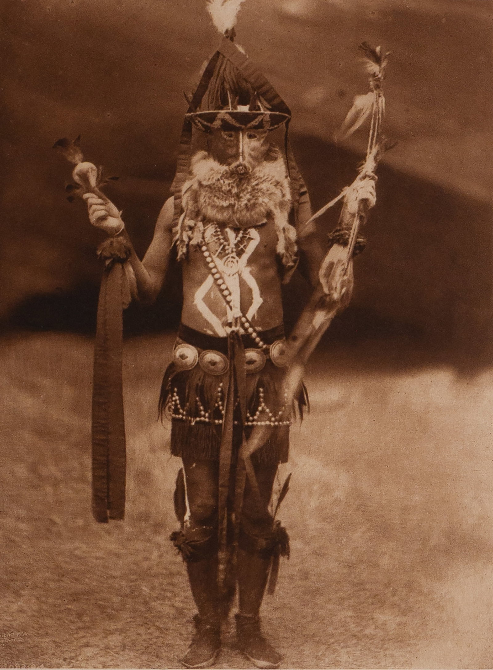 Zahadolzha - Navaho: This dramatic full-length portrait depicts a Navaho ceremonial dancer impersonating Zahadolzha, the mythological deity associated with the Yei or Holy People. The figure is adorned in elaborate ritual