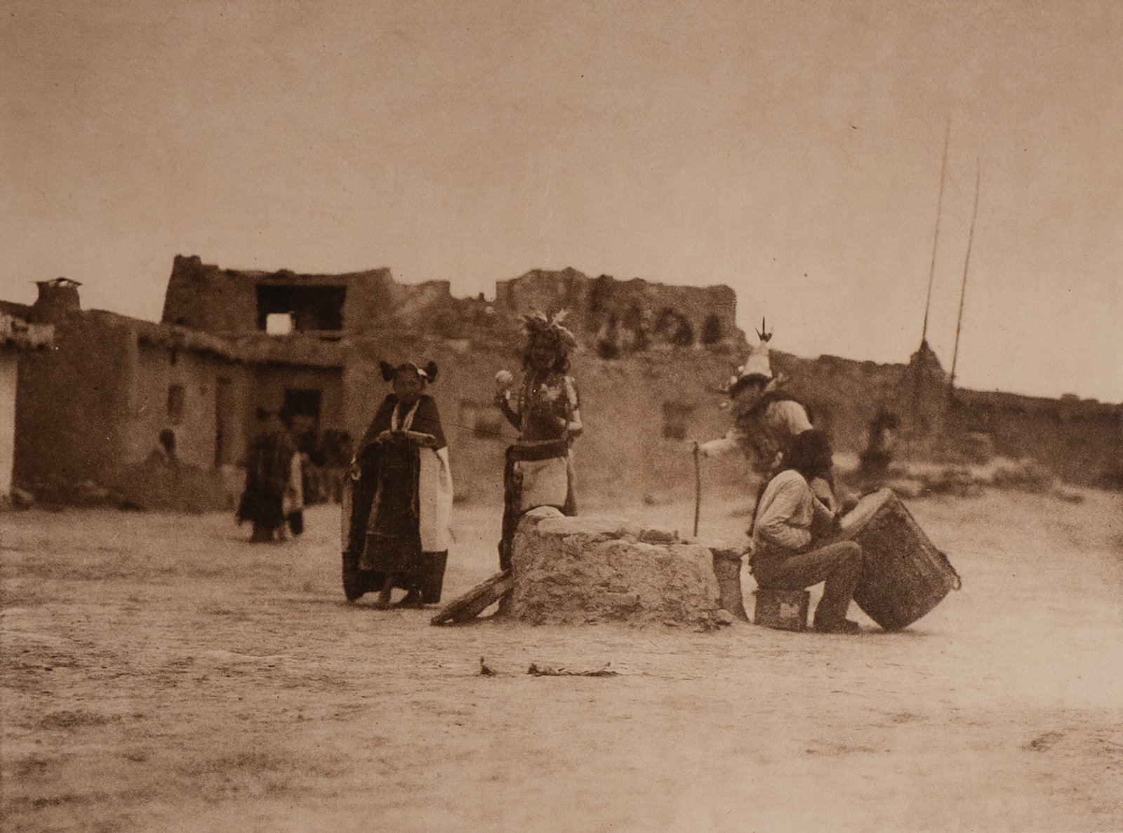 Sumaikuli Katsina at Hano: A rare and culturally significant image capturing the ceremonial presence of the Sumaikuli Katsina (Kachina) in the Hopi-Tewa village of Hano on First Mesa, Arizona. The katsina figure stands in the p