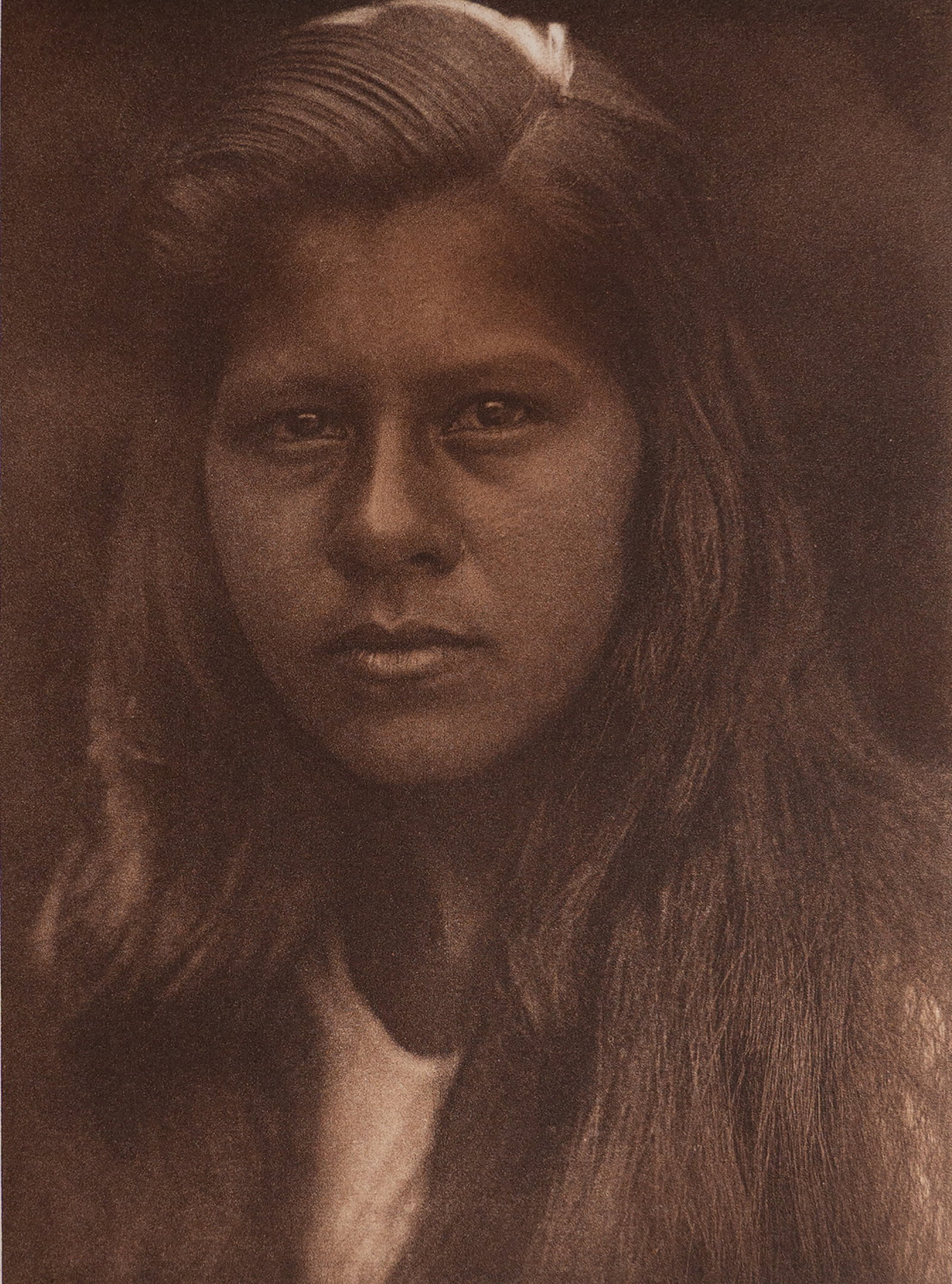 Sherwood Valley Girl - Pomo: A quiet, penetrating portrait of a young Pomo girl from Sherwood Valley in northern California. Her long hair frames her face, and her direct gaze meets the camera with calm confidence. Curtis’s sof