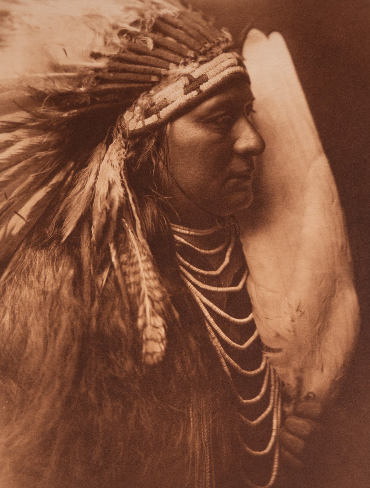 Nez Perce Brave: A powerful and composed portrait of a Nez Perce man, captured in three-quarter profile with his long hair braided and wrapped, wearing a simple, traditional garment. His calm and steady expression con
