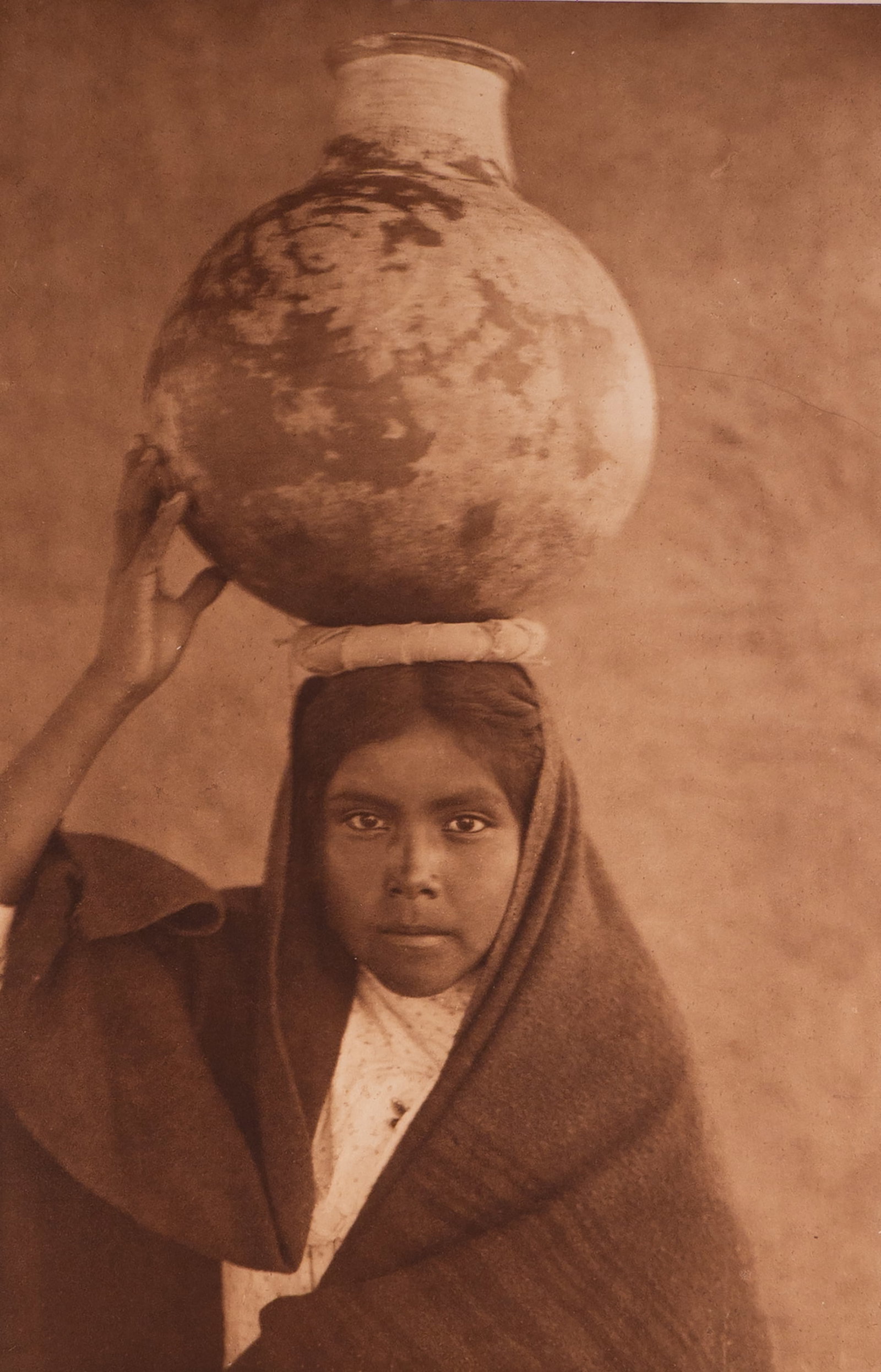 Qahatika Water Girl: This Edward Curtis photogravure is on Japanese Gampi Tissue paper.The young woman's steady, introspective gaze exudes quiet strength. Curtis’s minimalist approach compels us to connect with her huma