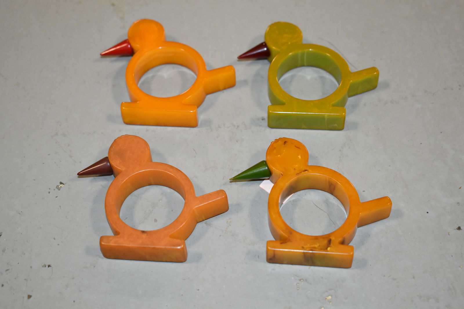 Lot (4) Bakelite Bird form Napkin Rings 2 1/2" T X 3": Lot (4) Bakelite Bird form Napkin Rings 2 1/2" T X 3" W- (3) CARMEL COLORED AND (1) LIGHT GREEN- IMPERFECTIONS 2 1/2" T X 3" W- (3) CARMEL COLORED AND (1) LIGHT GREEN- IMPERFECTIONS