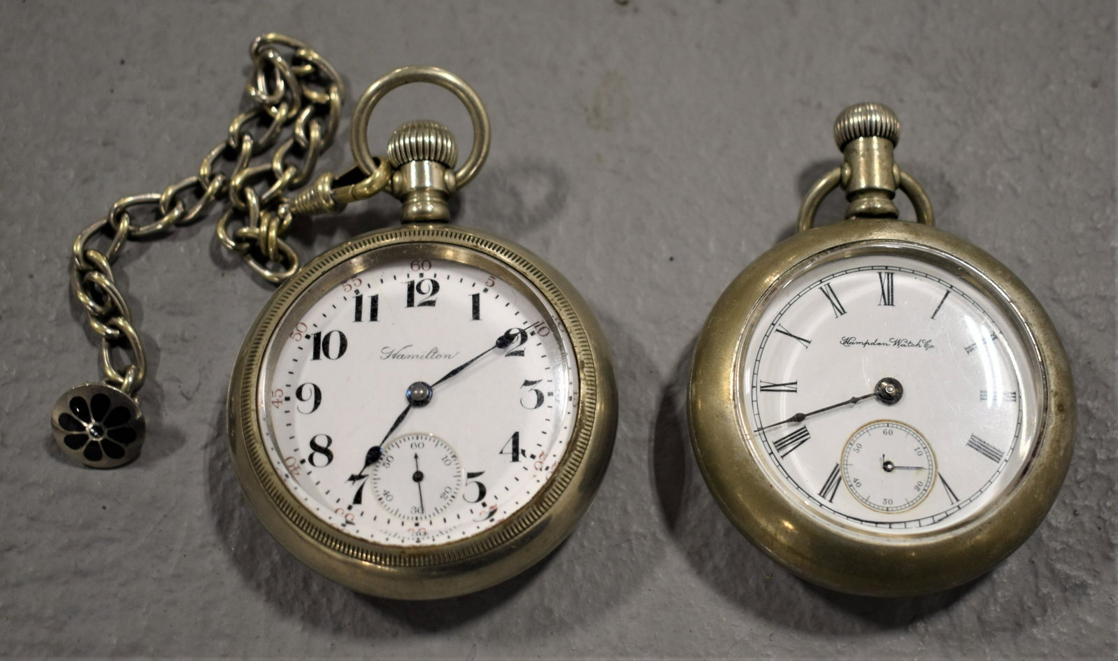 Lot (2) Open Face Pocket Watches: HAMPDEN WITH STAG CASE AND HAMILTON 17 JEWEL WITH PHILA WATCH CASE AND 8" WATCH CHAIN- AS IS- IMPERFECTIONS
