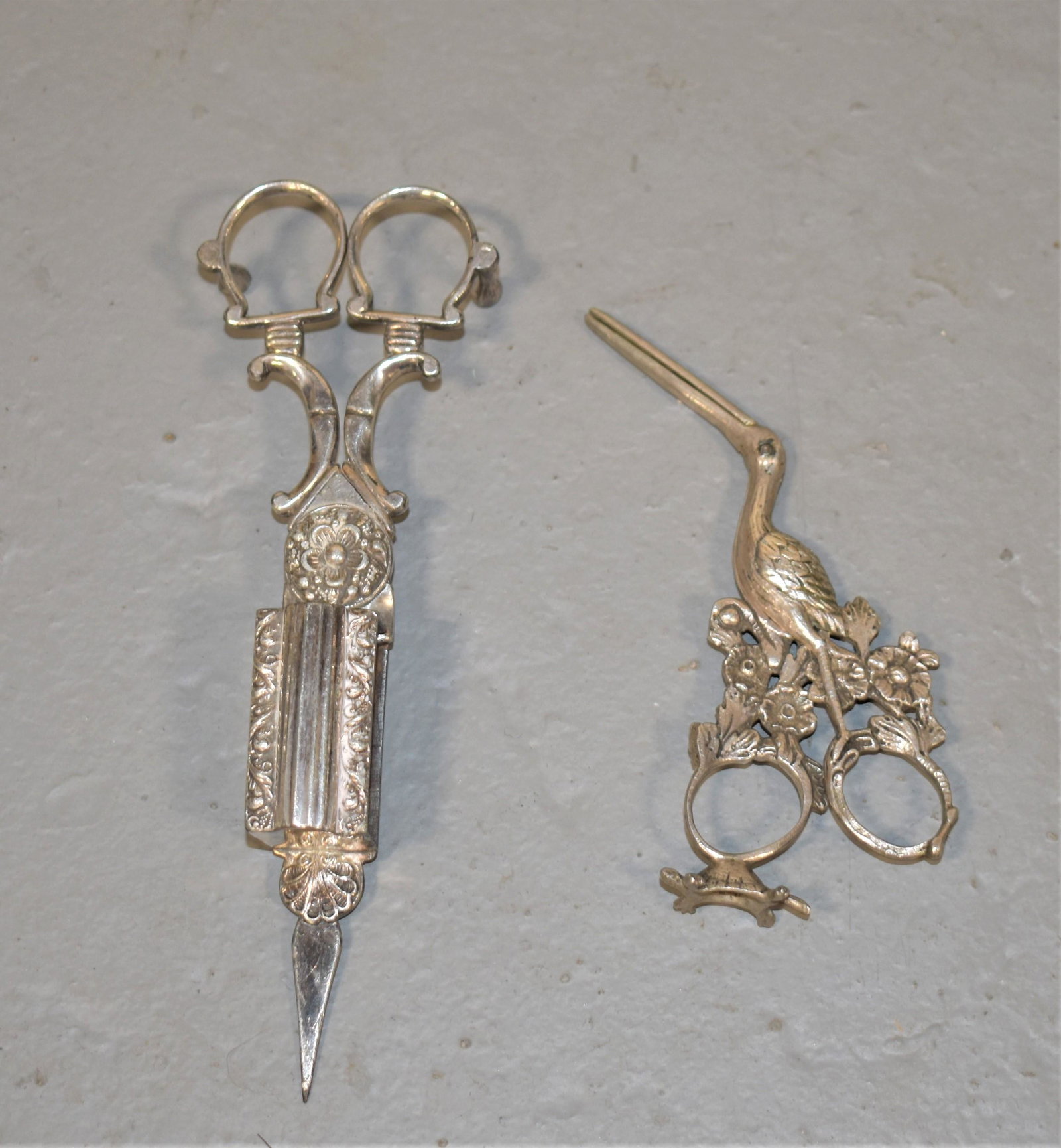 (2) Victorian Silver Plated Items: 5" PAIR OF SILVER STORK CLAMPS (UMBILICAL CORD SCISSORS) PROBABLY .800 SILVER TOGETHER WITH 7" PAIR OF VICTORIAN FANCY SILVERPLATE CANDLE SNUFFERS- WEAR AND IMPERFECTIONS