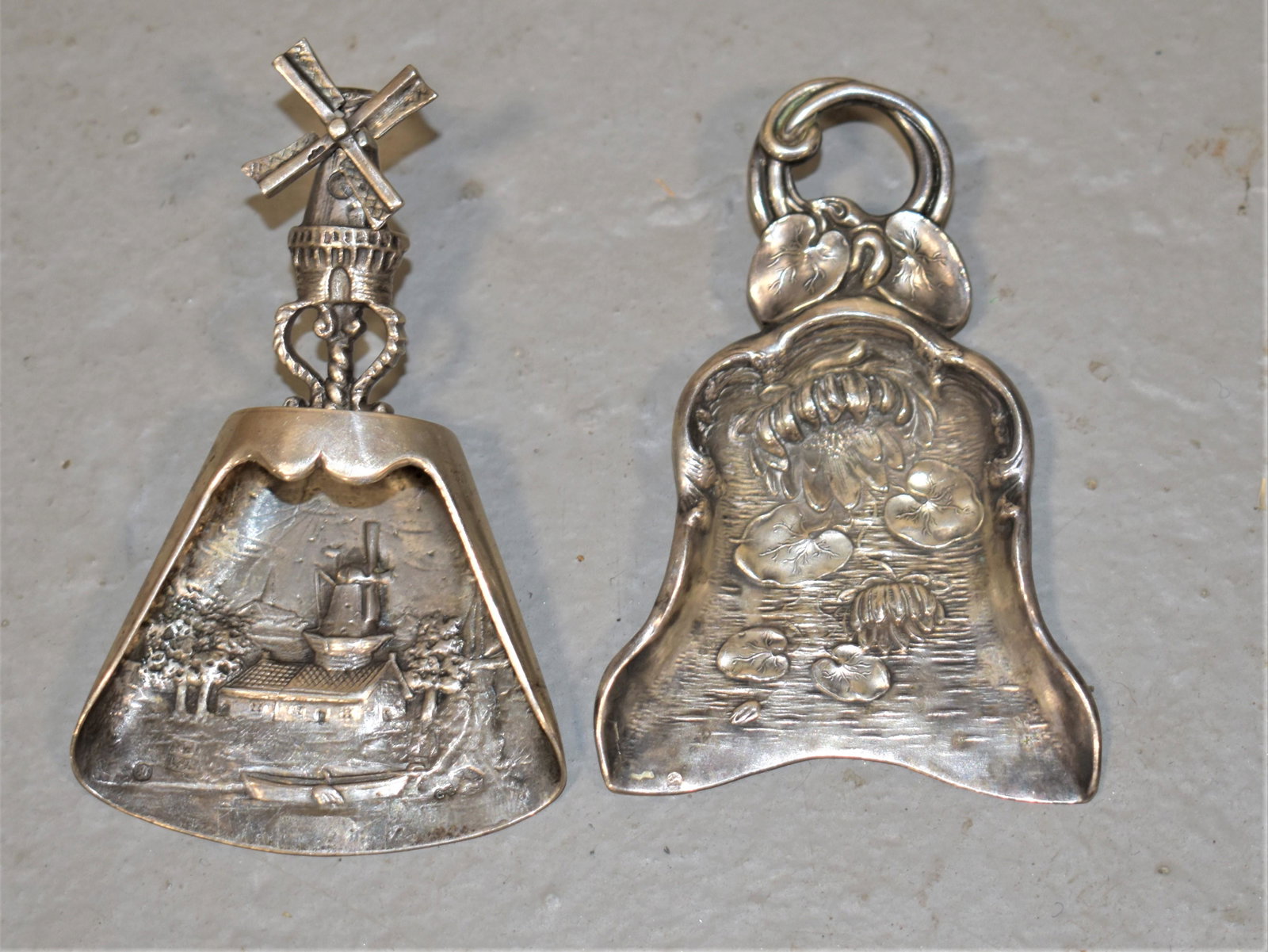 (2) Repousse Silver Tea Cady Spoons: (1) 3 1/2" REPOUSSE SPOON WITH WINDMILLS MARKED BOSSARD & SOHN AND (1) 3 1/2" REPOUSSE WITH WATER LILLIES AND OTHER VEGITATION MARKED WITH UNGER BROS HALLMARK- STERLING- WEAR AND IMPERFECTIONS