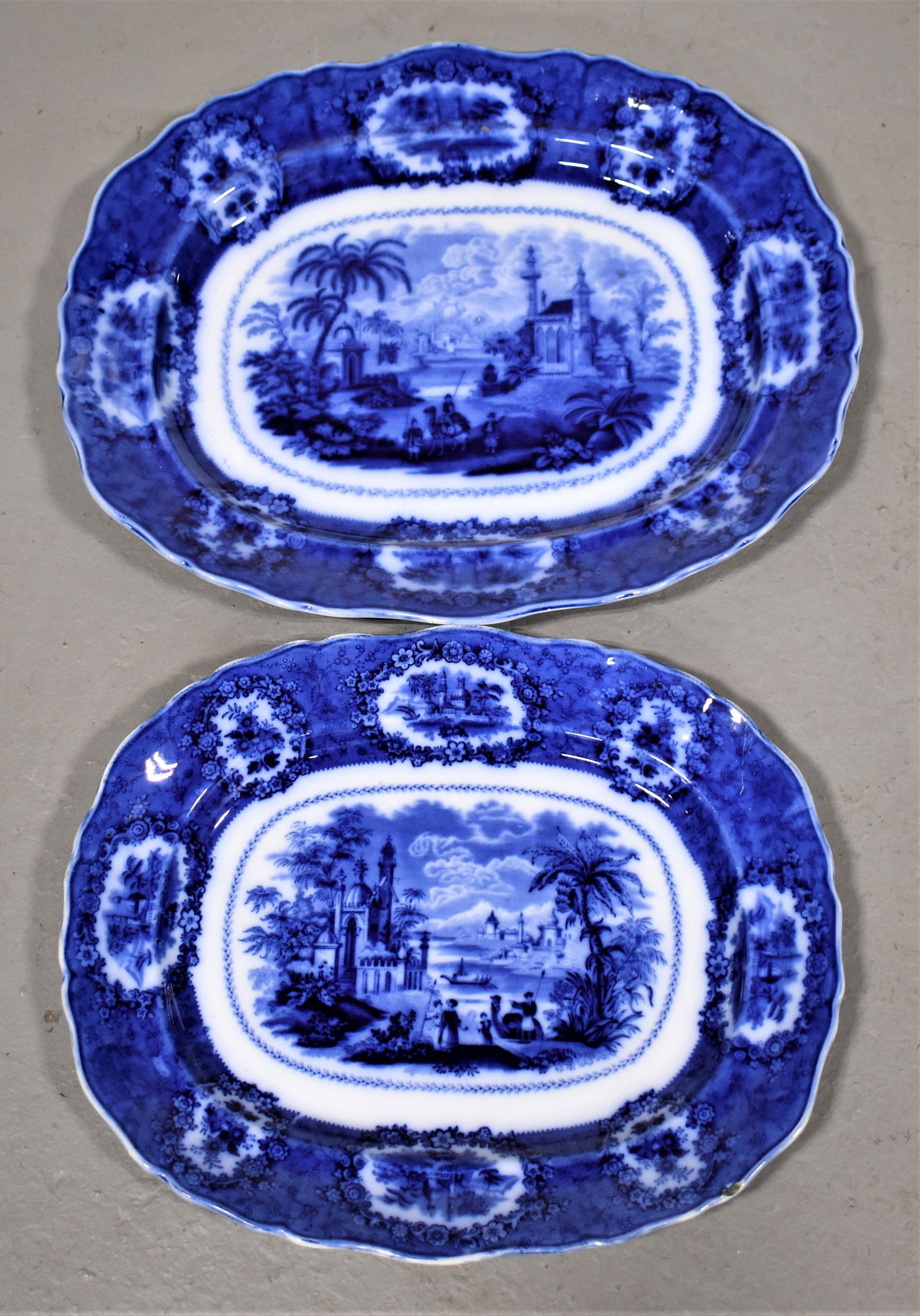 2 Flow Blue Platters: GRADUATED SET OF 2 FLOW BLUE PLATTERS- 15" AND 17 1/2"- ORIENTAL PATTERN BY W. RIDGWAY- SMALL PLATTER WITH SMALL 1/2 CHIP TOP RIM- WEAR AND IMPERFECTIONS