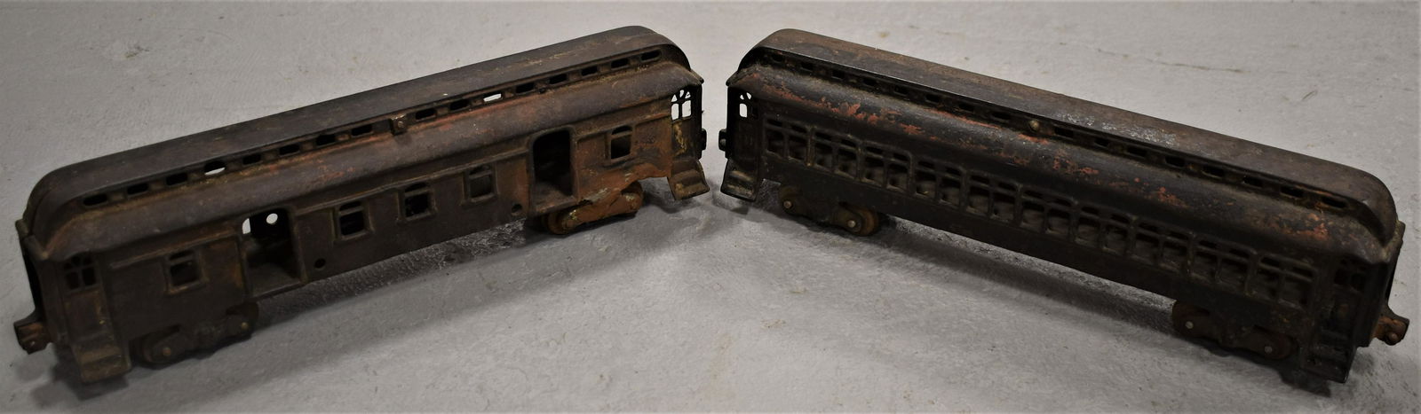 (2) Cast Iron Train Cars: (2) EARLY 20TH CENTURY TOY CAST IRON TRAIN PASSENGER CARS - TRACES OF OLD RED AND BLACK PAINT - 16 1/2" X 4 1/2" TALL - RUST, WEAR, REPAIRS TO ONE SET OF WHEELS - IMPERFECTIONS