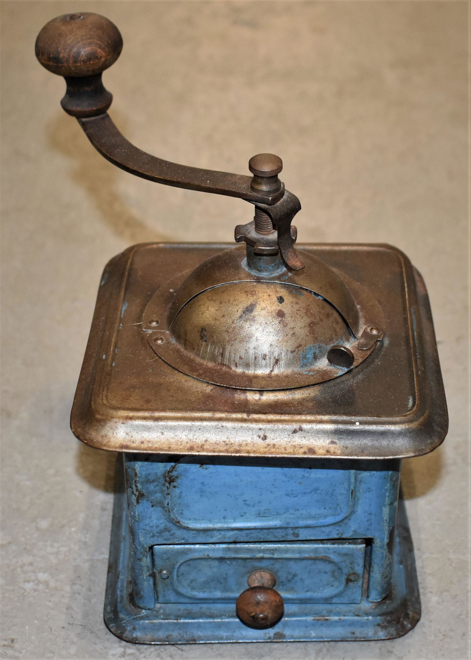 Early Painted Tin Coffee Mill: LATE 19TH EARLY 20TH CENTURY PAINTED TIN COFFEE MILL IN OLD BLUE - CAST IRON AND WOODEN HANDLE - TIN BODY WITH LOWER DRAWER WITH WOODEN KNOB - 5 1/2"SQ - 7 3/4"T WITH HANDLE - WEAR, IMPERFECTIONS