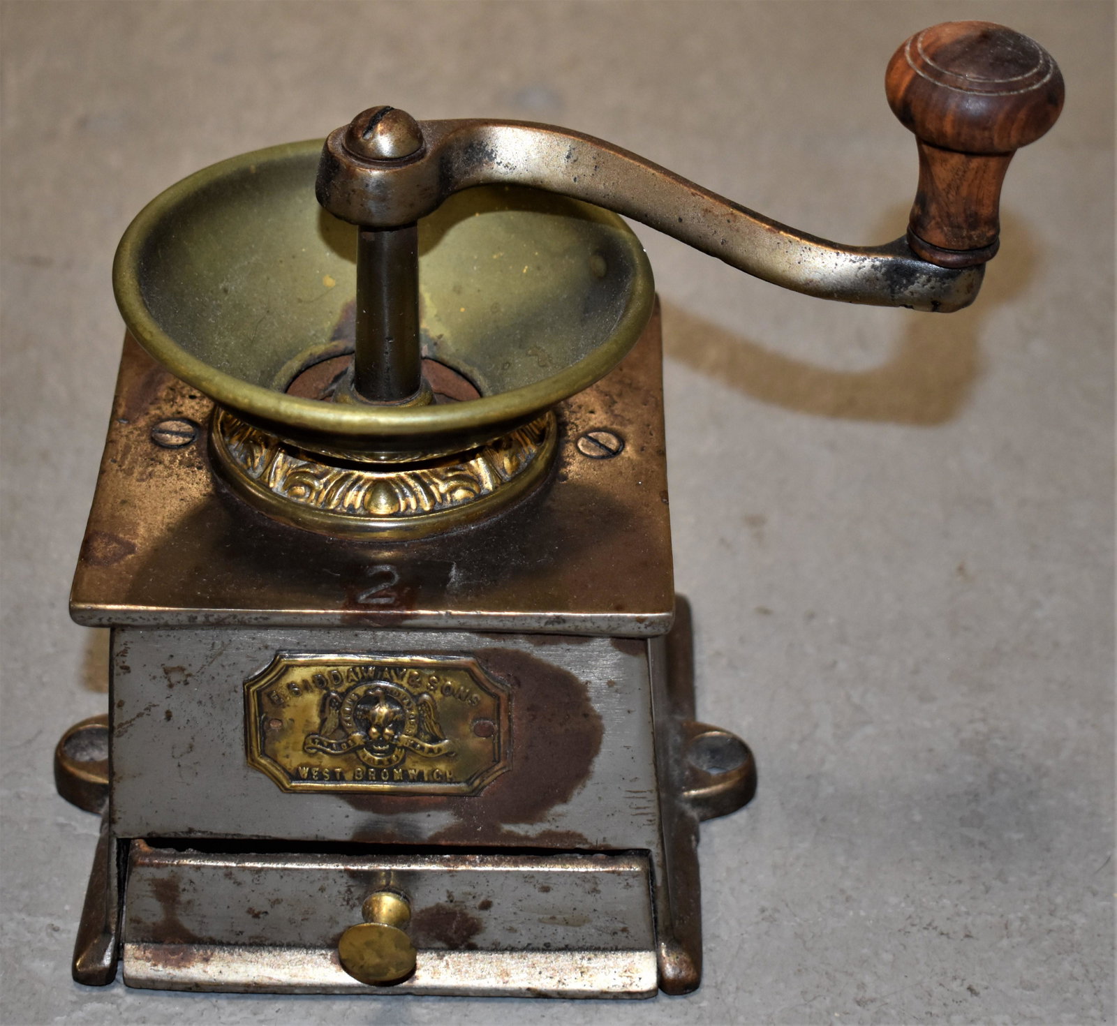 Iron and Brass Coffee Mill: LATE 19TH CENTURY CAST IRON AND BRASS COFFEE MILL - TAG READS "E. SIDDAWAY AND SONS WEST BROMWICK #2" - 6"W X 5"D X 7 1/2"T WITH HANDLE - WEAR, IMPERFECTIONS
