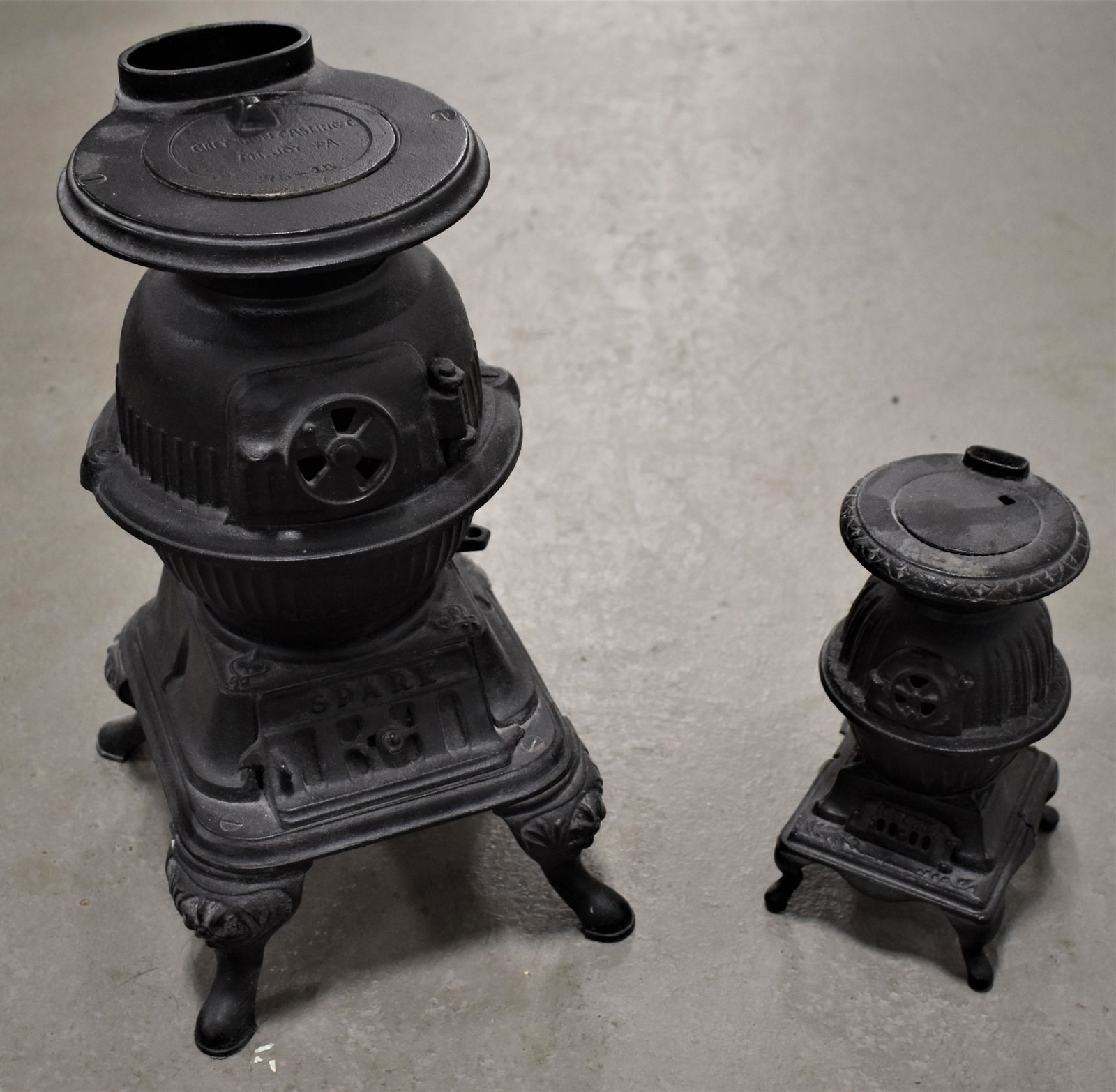 (2) Cast Iron Salesman Sample Potbelly Stoves: (2) LATE 20TH CENTURY SALESMAN SAMPLE POTBELLY STOVES - (1) 8" MARKED BLAZE AND (1) 14" MARKED SPARK GREY IRON CASTING CO. MT. JOY PA. 75-15 - IMPERFECTIONS