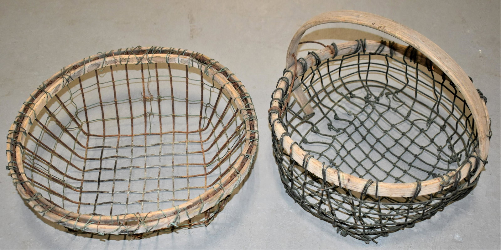 2 Bent Wood and Wire Clam Baskets: (2) EARLY 20TH CENTURY CLAM BASKET - (1) WITH BENT WOODEN FRAME AND HANDLE 13" ROUND x 11 1/2"T WITH HANDLE TOGETHER WITH (1) BENT WOOD FRAME - 15" ROUND TOP x 8 12" x 5 1/2"T - WEAR, OXIDATION AND IM