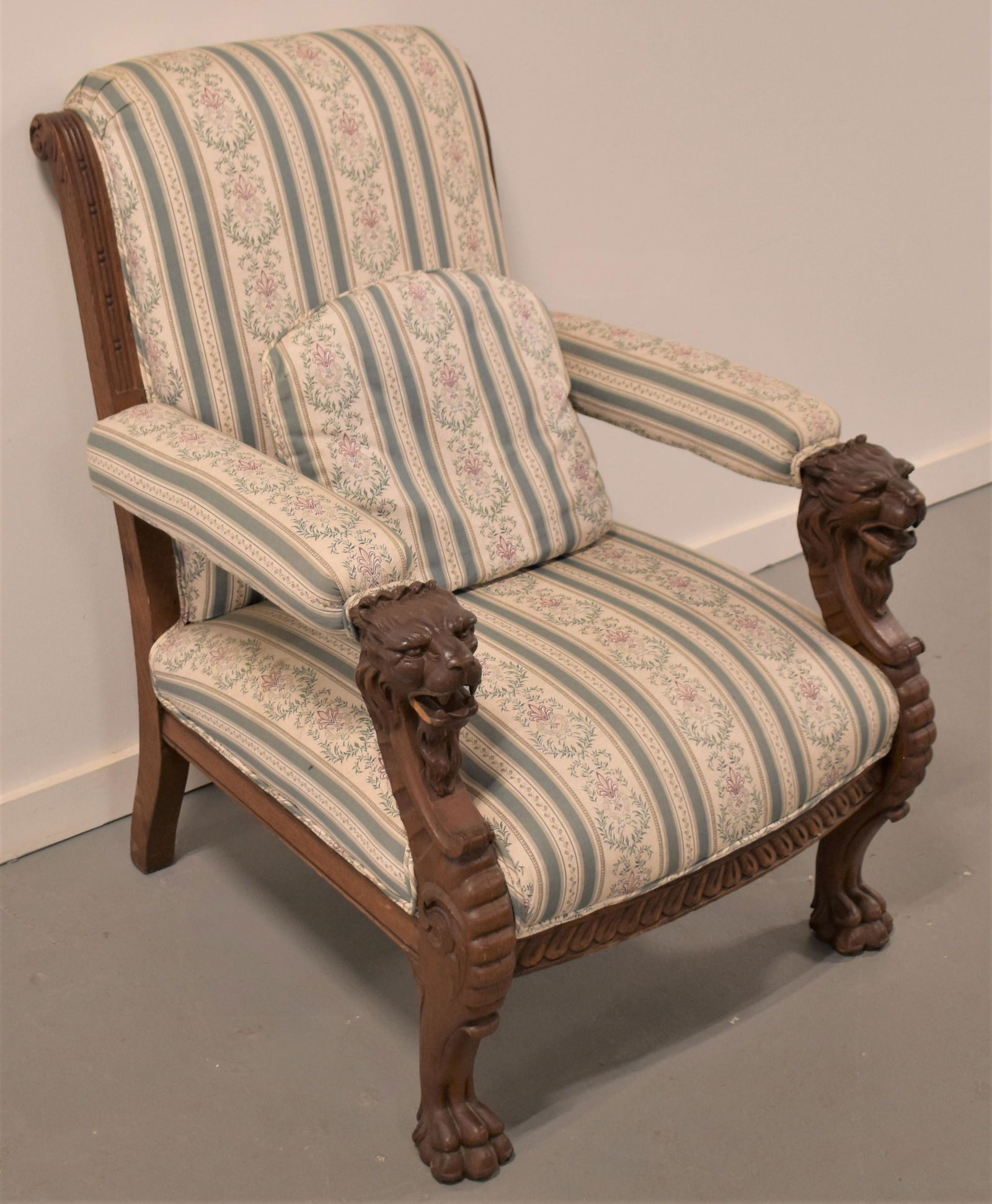 Ornately Carved Victorian Oak Arm Chair: 19TH CENTURY ORNATELY CARVED UPHOLSTERED ARM CHAIR WITH BOLDLY CANED LIONS AND PAW FEET 38"T X 28" W X 32"D - CHIP TO LIONS MOUTH RIGHT SIDE, NEWLEY UPHOLSTERED WITH CUSHION, WEAR AND IMPERFECTIONS