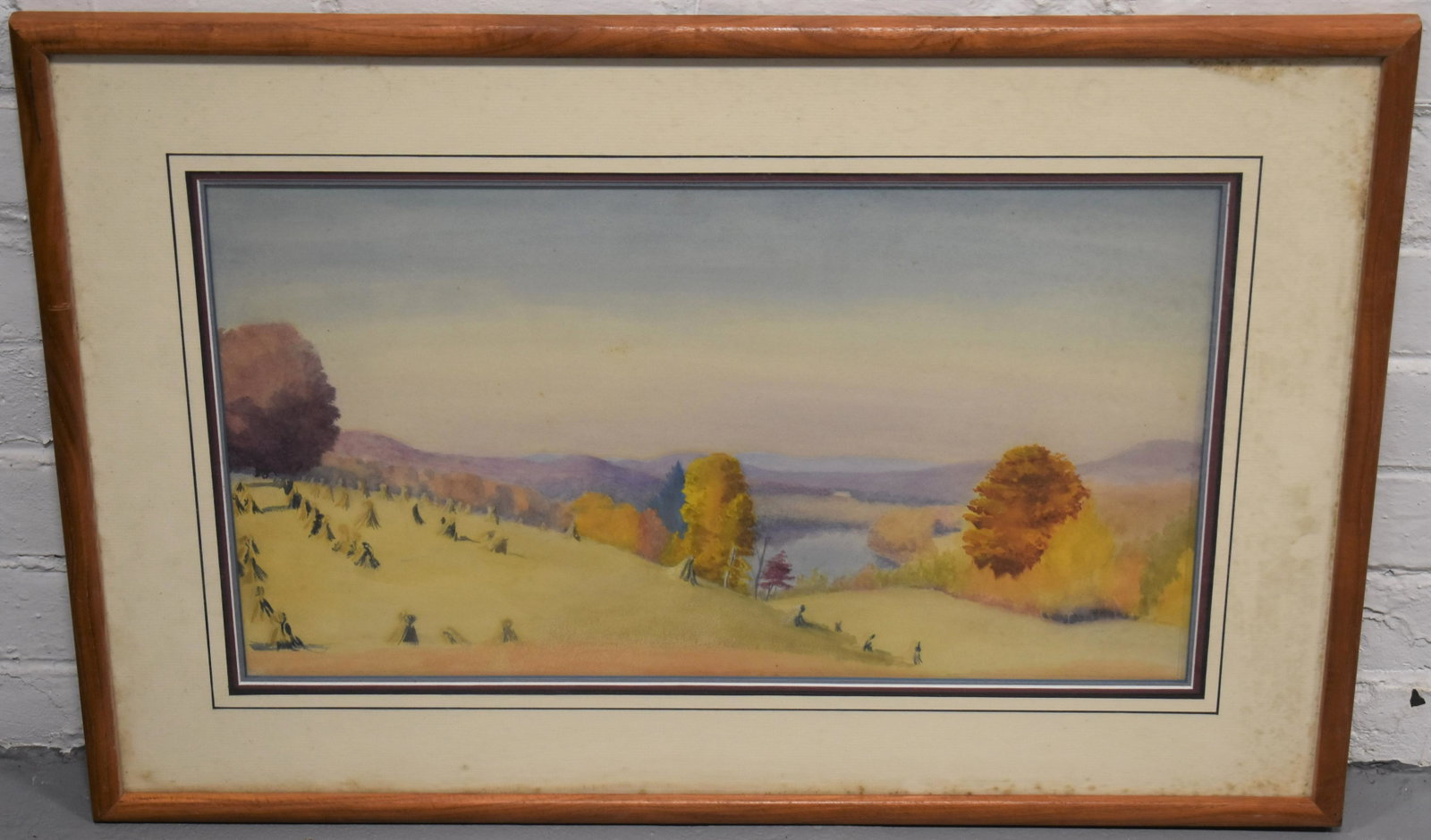 20th Century Autumn Landscape Watercolor Painting: 20TH CENT WATERCOLOR PAINTING OF A N AUTUMN LANDSCAPE W/ MOUNTAINS, LAKES AND HAYSTACKS- UNSIGNED MATTED AND FRAMED - 11 1/4" X 19 3/4'" - TONING , SMALL STAINS, IMPERFECTIONS