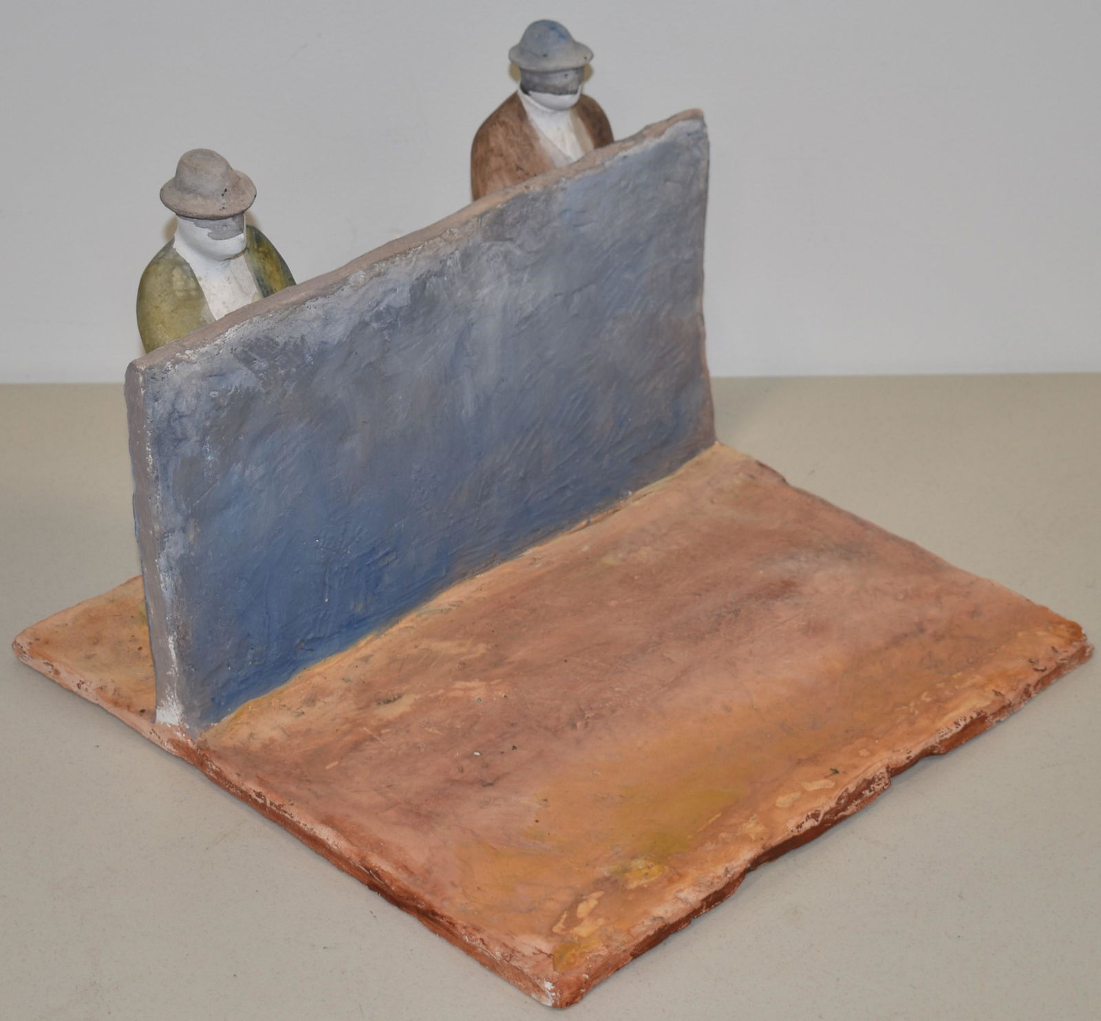 ROGER PRINCE CLAY SCULPTURE: PAINTED CLAY SCULPTURE OF 2 MEN STANDING BEHIND WALL PEEING - SIGNED PRINCE - 9 1/2" T X 13 1/4" W X 13 1/4" - WEAR & IMPERFECTIONS