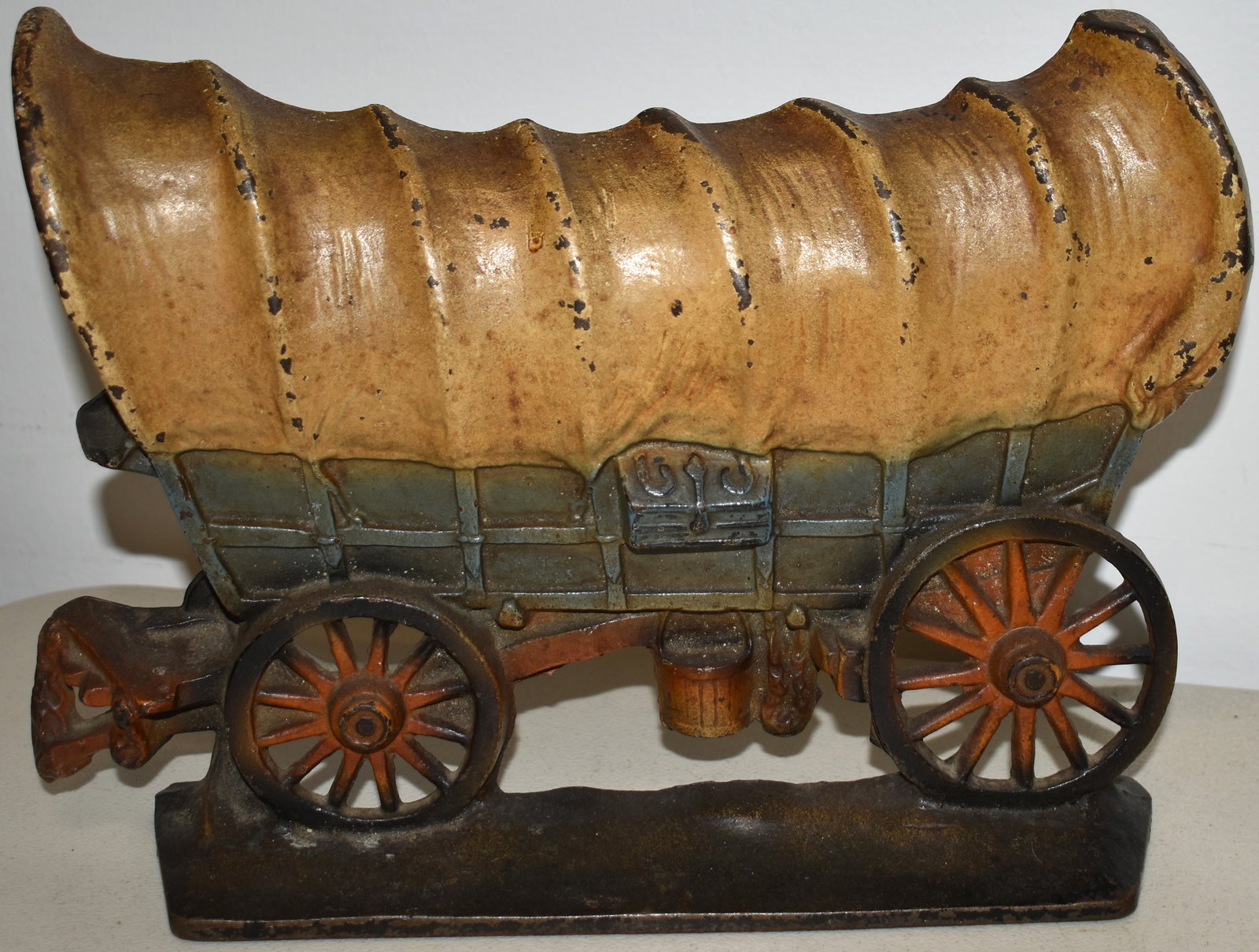 PAINTED CAST IRON CONESTOGA WAGON DOORSTOP: 11 1/2" PAINTED CAST IRON CONESTOGA WAGON DOORSTOP - 11 1/2" L X 8 1/2" T - MARKED ON BACK COPYRIGHT 1930 - WEAR, MINOR LOSSES TO PAINT & IMPERFECTIONS