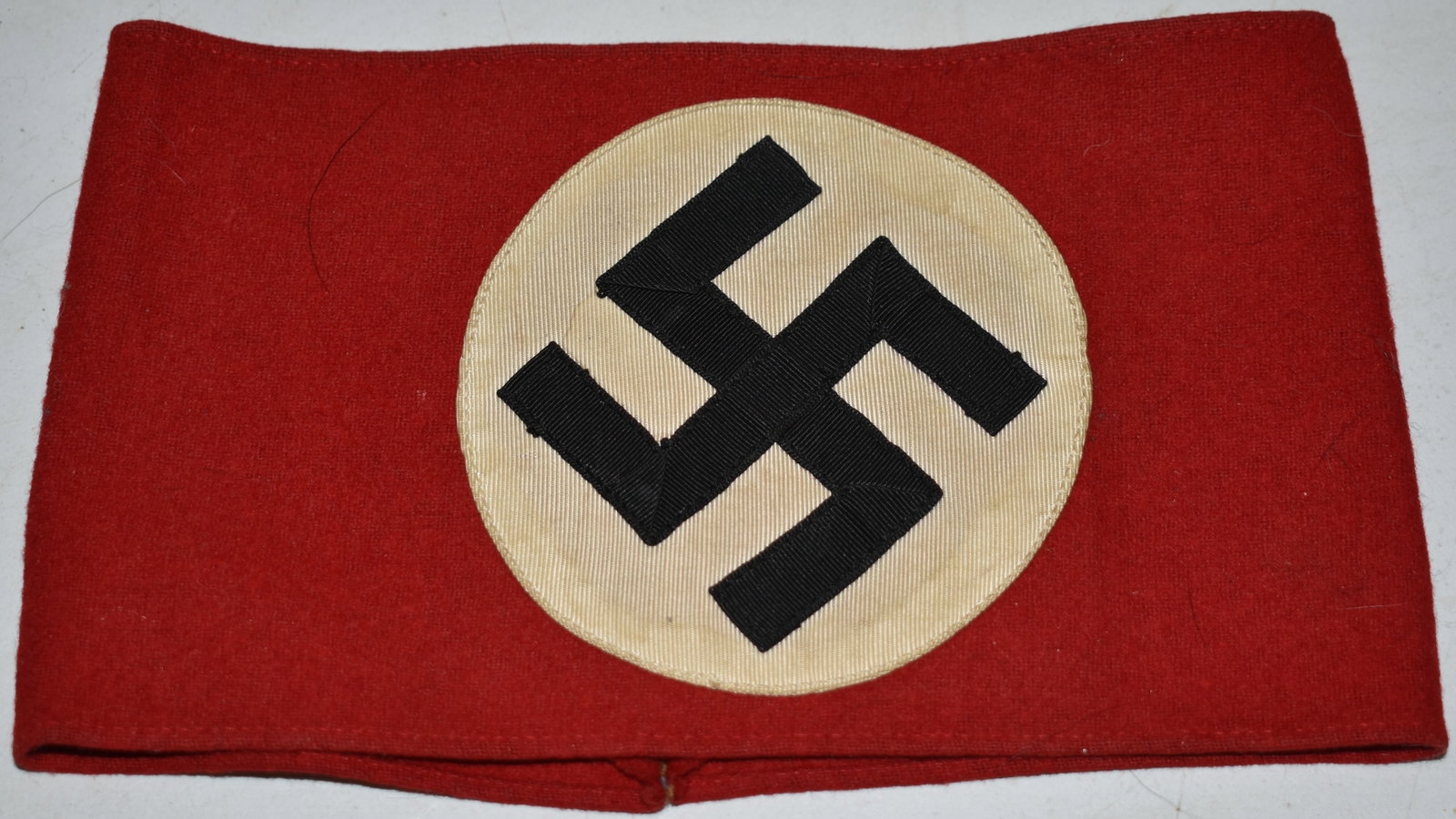 WWII NAZI GERMAN ARMBAND W/ SWASTIKA INSIGNIA: RED TEXTILE ARMBAND W/ BLACK & WHITE NAZI INSIGNIA (SWASTIKA) - 8" X 4 1/2" - IMPERFECTIONS