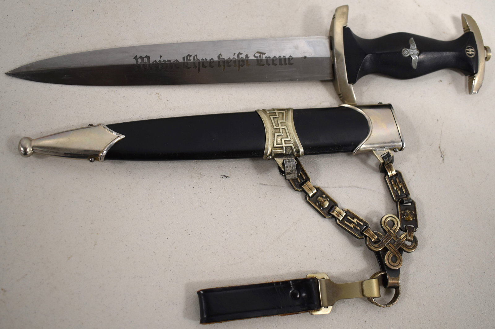 1936 HIMMLER NAZI SS DAGGER W/ SCABBARD: SS HEINRICH HIMMLER RZM M7/36 DAGGER W/ SCABBARD - INSCRIBED W/ SS MOTTO " MEINE HEISST TREUR" REVERSE " IN HERZICHER KAMERADSCHAFT H. HIMMLER - RZM IN DOUBLE CIRCLE M7/36 IN BLACK METAL SHEATH W/ SKU